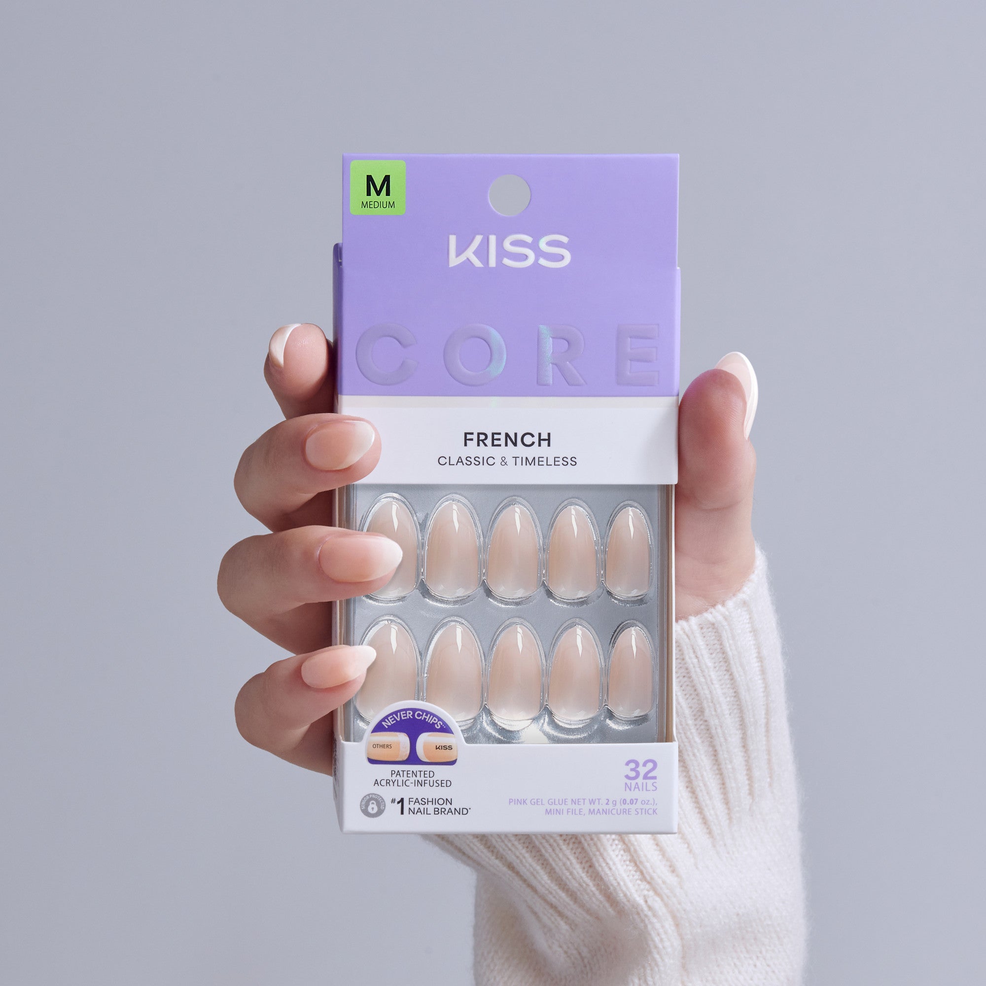 KISS Core French nails, medium size, 32 classic nude press-on nails in packaging held by hand.