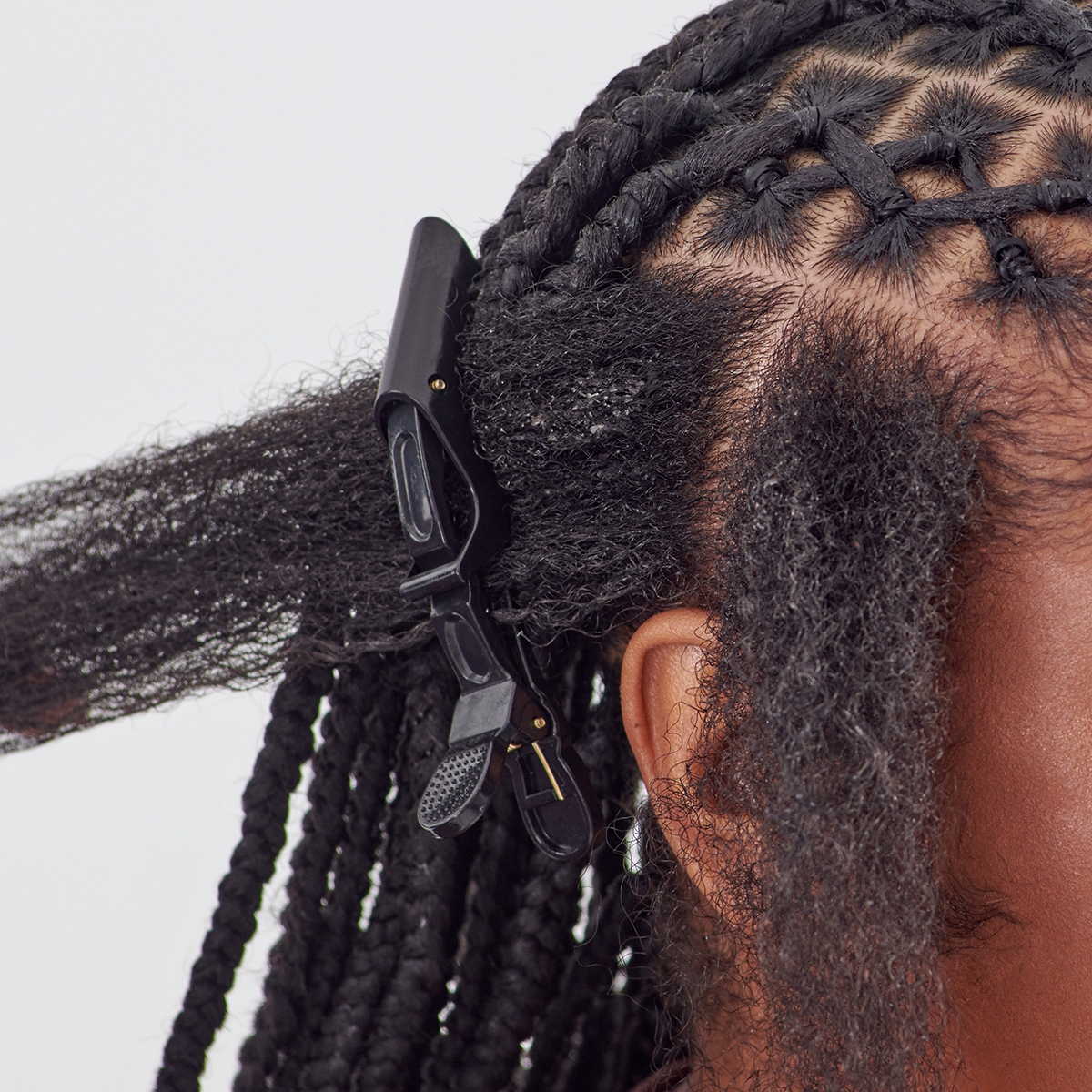Black alligator hair clip securing a section of natural textured hair on the side of a person&