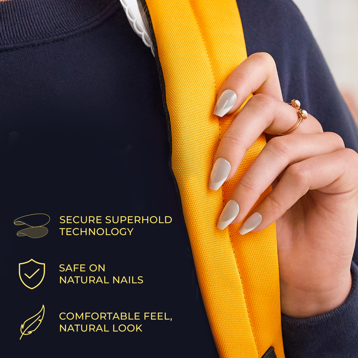 Hand with press-on nails in soft gray heart-shaped design holding a yellow strap, text highlights secure hold, safe on natural nails, and comfortable natural feel.