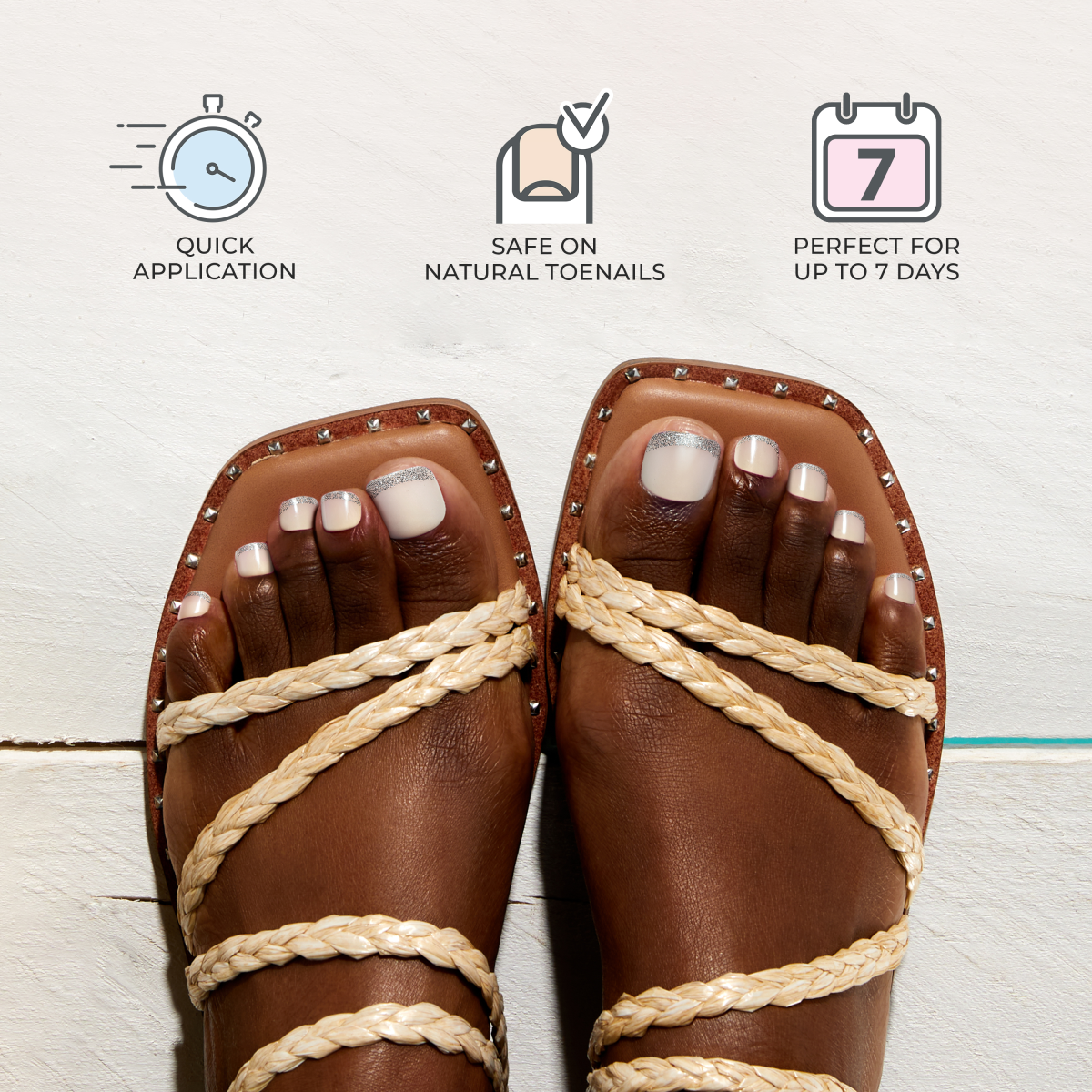 Feet wearing strappy tan sandals with white press-on toenails featuring silver glitter tips, accompanied by icons highlighting quick application, safety for natural toenails, and up to 7 days of wear.
