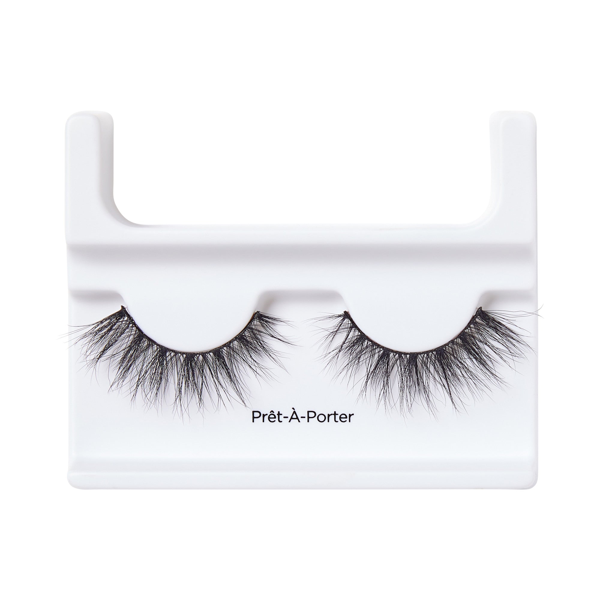 Black voluminous false eyelashes with wispy, crisscrossed strands displayed on a white plastic holder labeled \