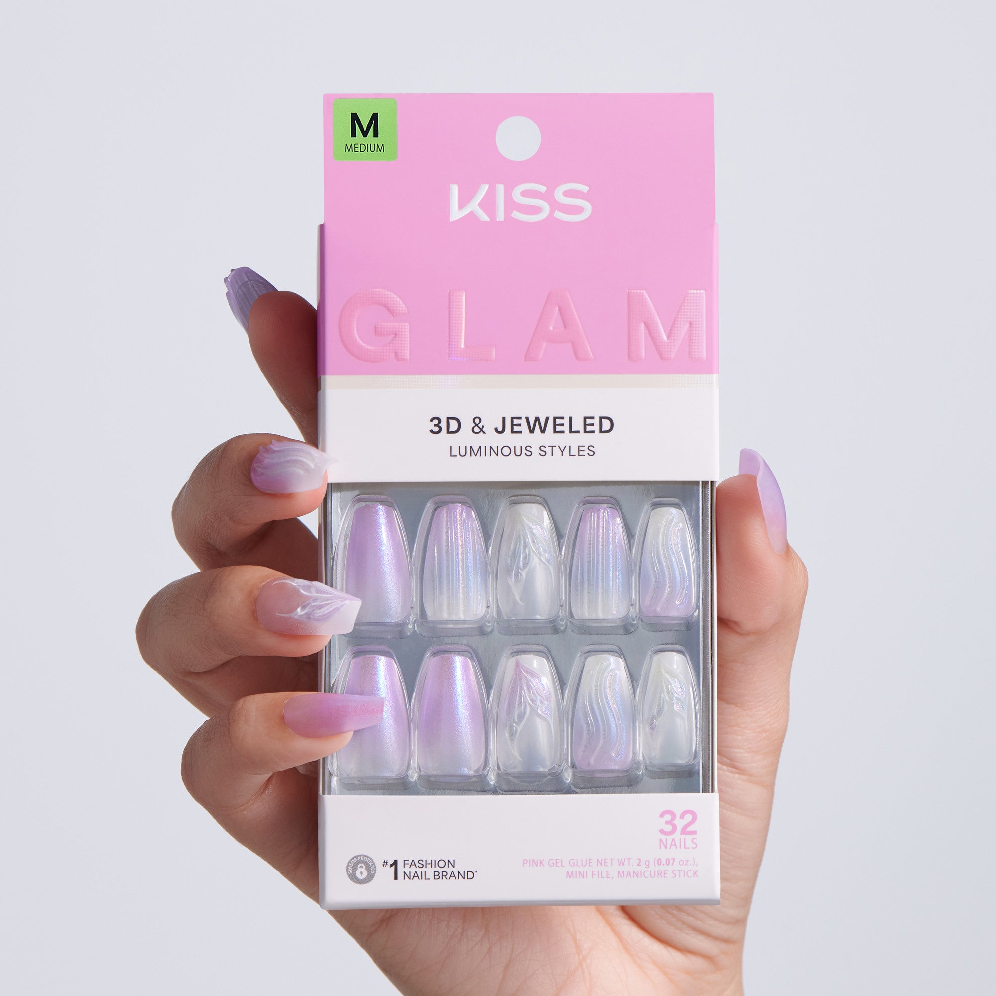 Kiss Glam 3D & Jeweled nail art packaging held by a hand with purple nail polish.