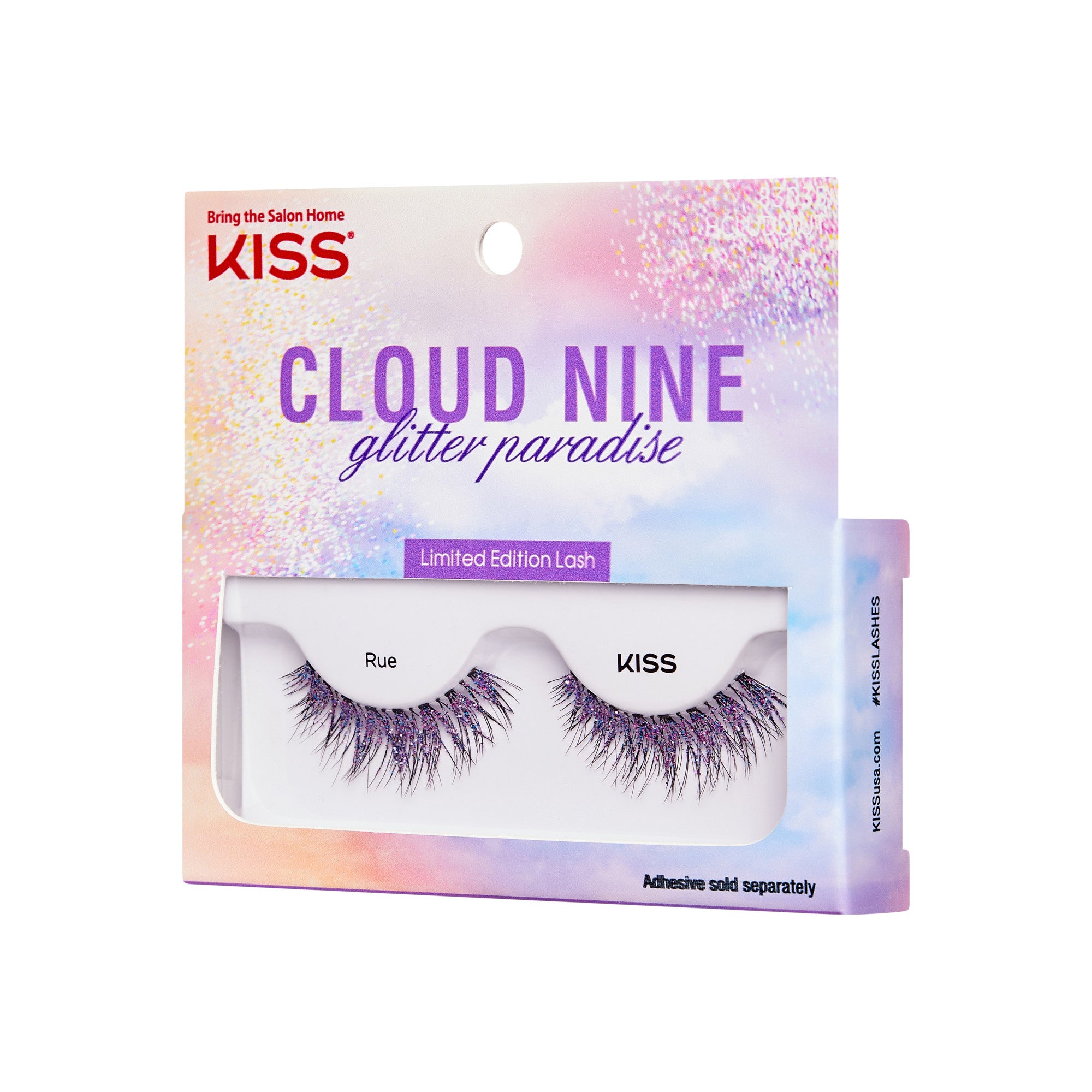 The image shows a product package for "KISS Cloud Nine Glitter Paradise" limited edition lashes. The packaging is colorful with a gradient of pastel hues, including pink, purple, and blue, and features a glittery design. The top of the package has the KISS logo and the tagline "Bring the Salon Home." The lashes are named "Rue" and are visible through a clear window in the packaging. The bottom of the package notes that adhesive is sold separately.