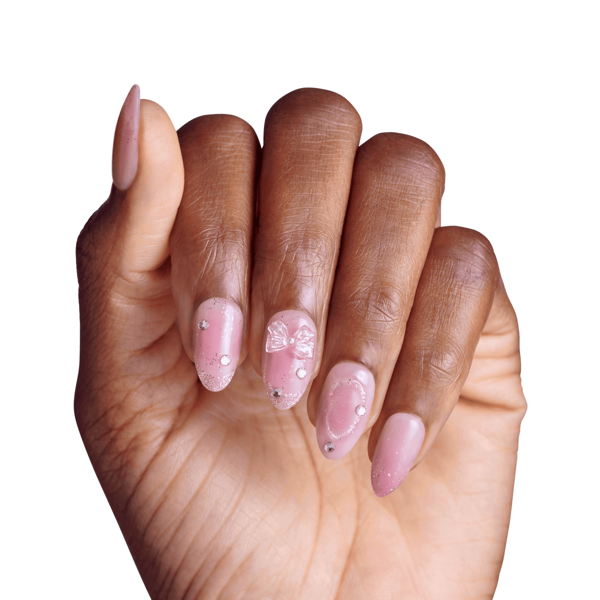 Manicured hand displaying pink gel nails with rhinestone embellishments and bow design.