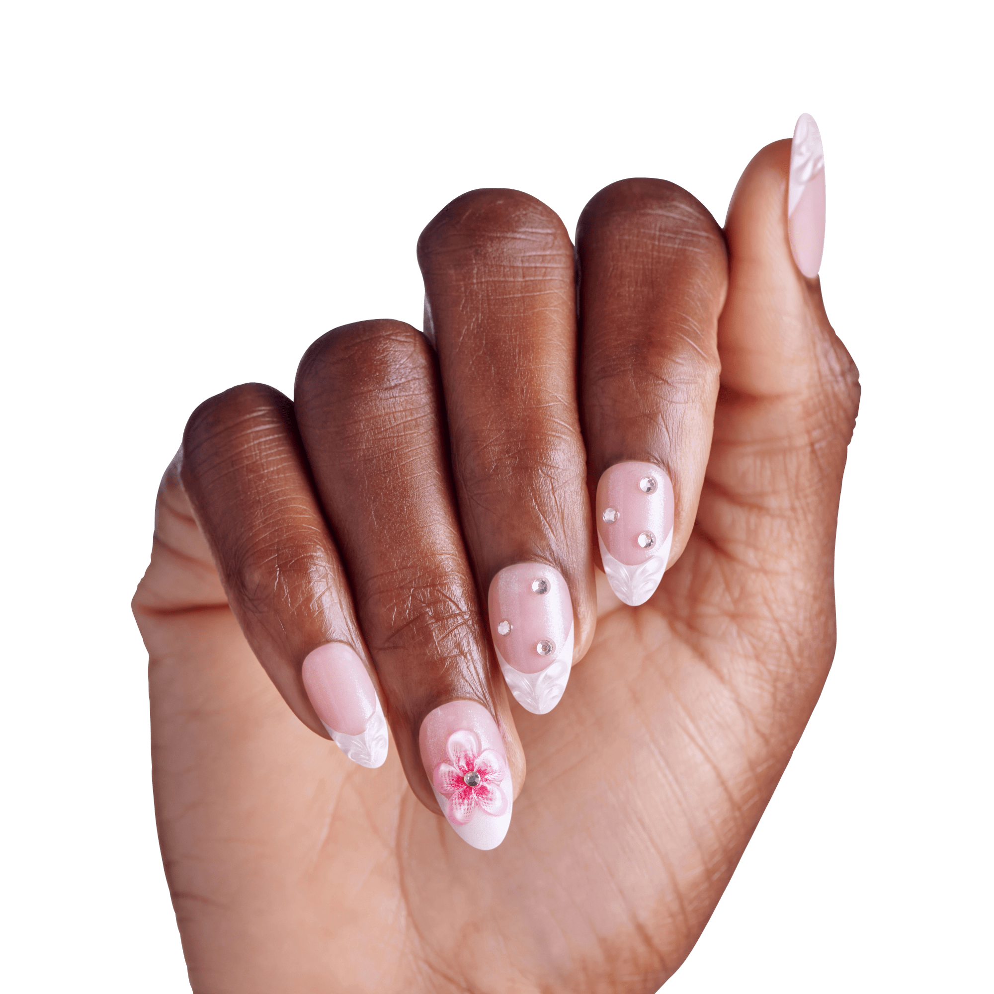Hand with almond nails featuring pink polish, white tips, rhinestones, and floral nail art design.