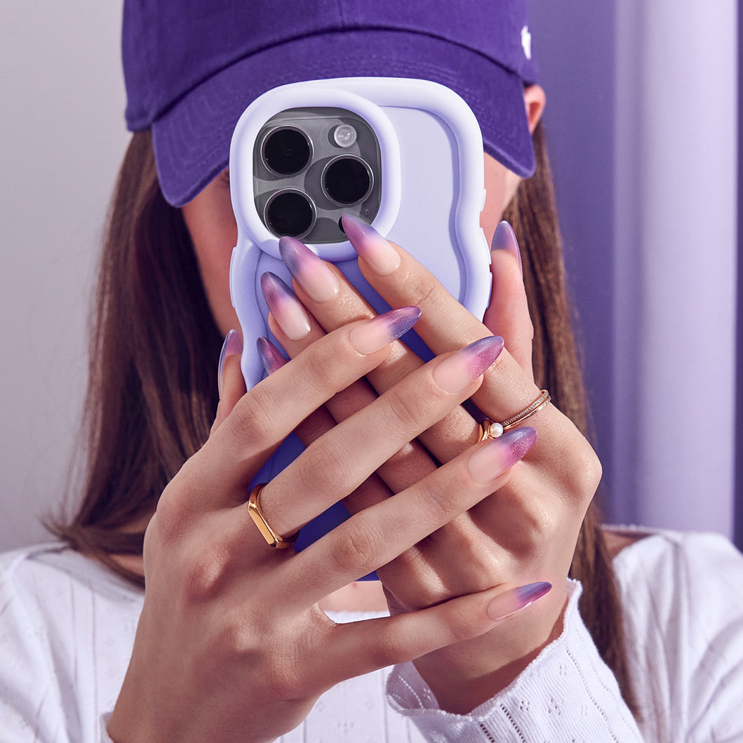 Person holding a phone with a purple case against a purple background