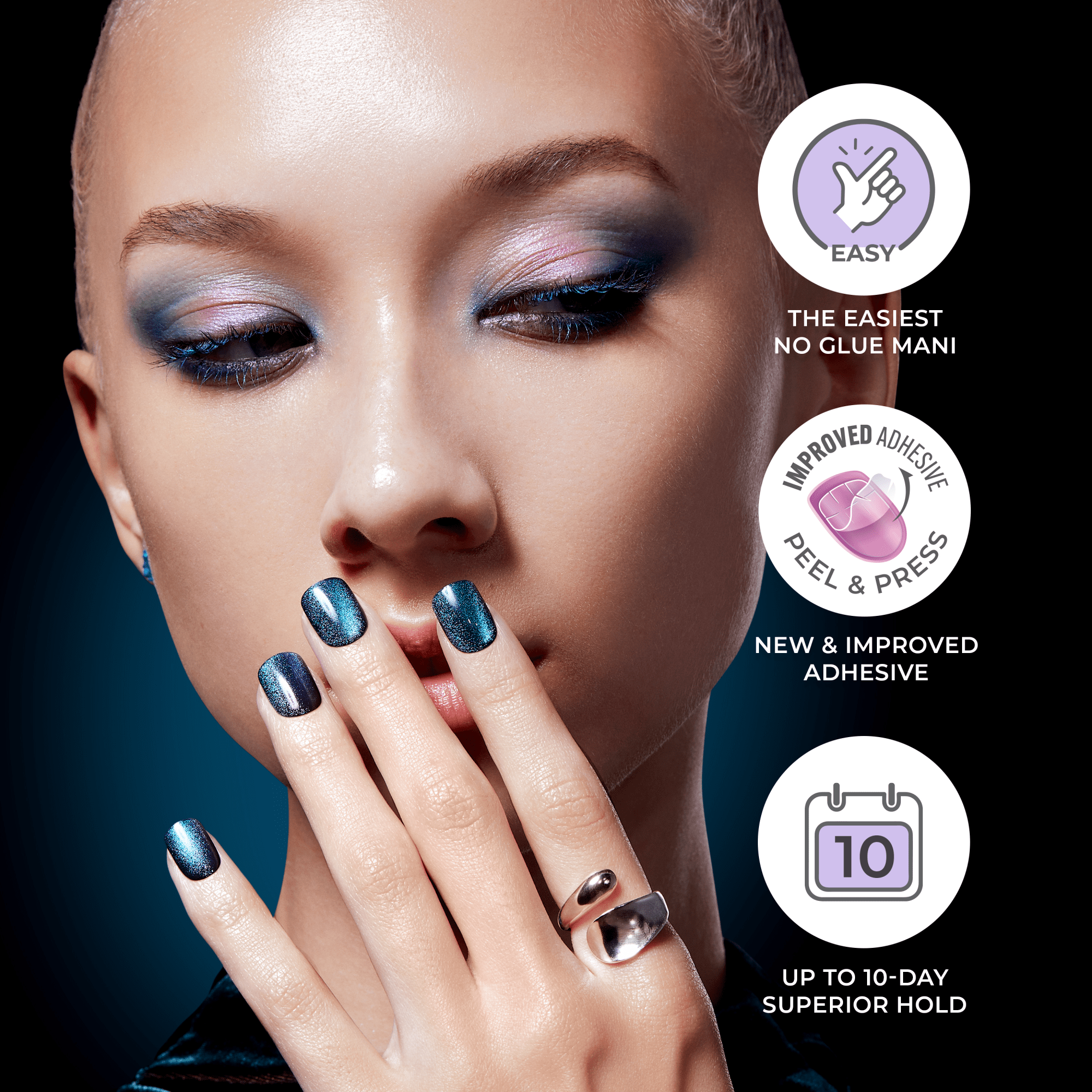 Close-up of a woman with shimmering celestial blue press-on nails, wearing a silver ring, with eye makeup in matching blue and purple tones. Text highlights easy no-glue application, improved peel-and-press adhesive, and up to 10-day superior hold.