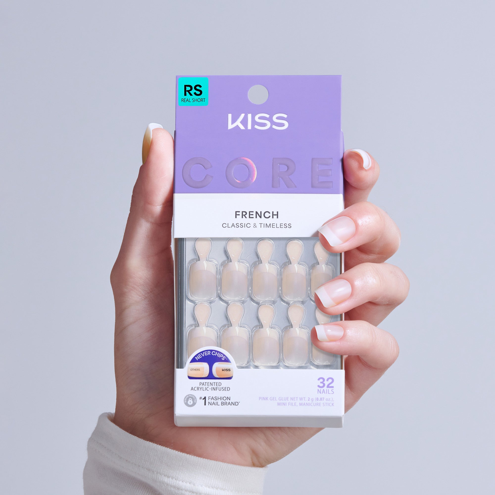 Hand holding KISS Core French Classic & Timeless press-on nails package with 32 nails.