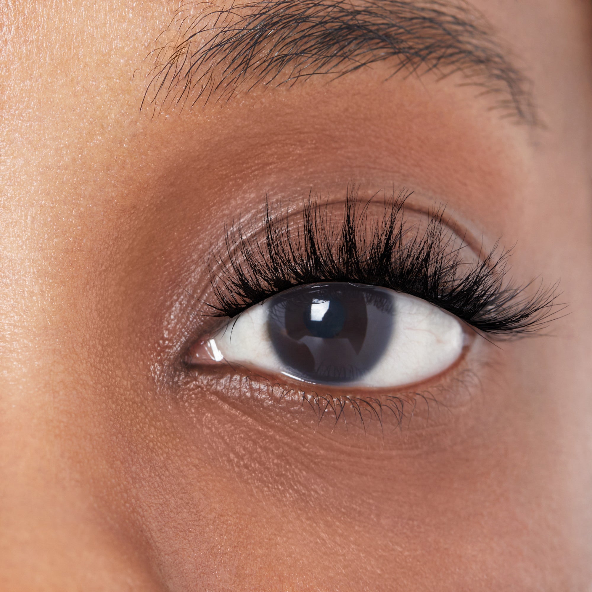 Close-up of a person modeling faux mink lashes that are full and plush. Lashes are KISS Lash Couture in &
