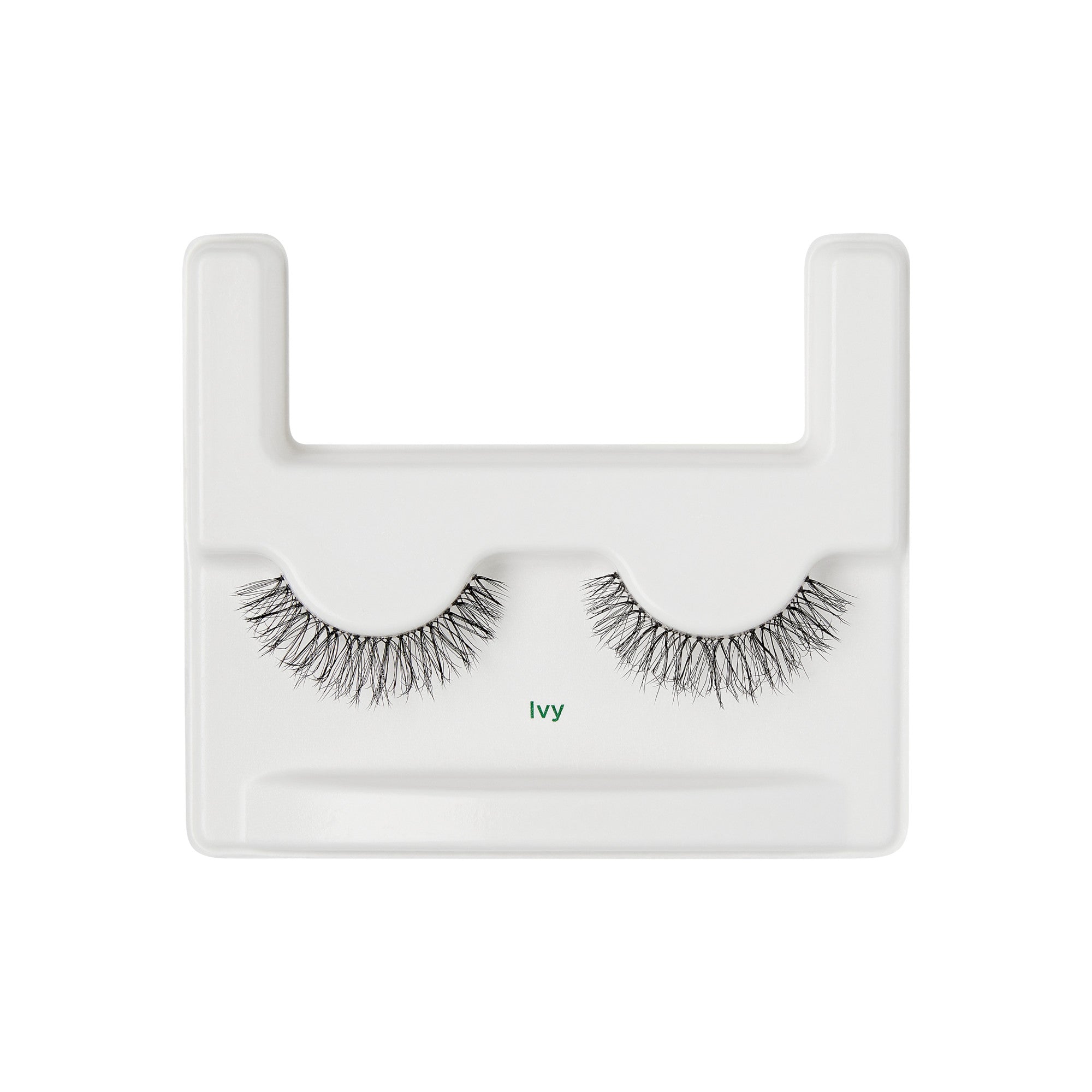 The image shows a pair of false eyelashes displayed on a white plastic tray. The tray has a rectangular shape with a U-shaped cutout at the top. The eyelashes are arranged side by side, with the label "Ivy" printed in green text below them. The lashes are dense and have a natural, wispy appearance.