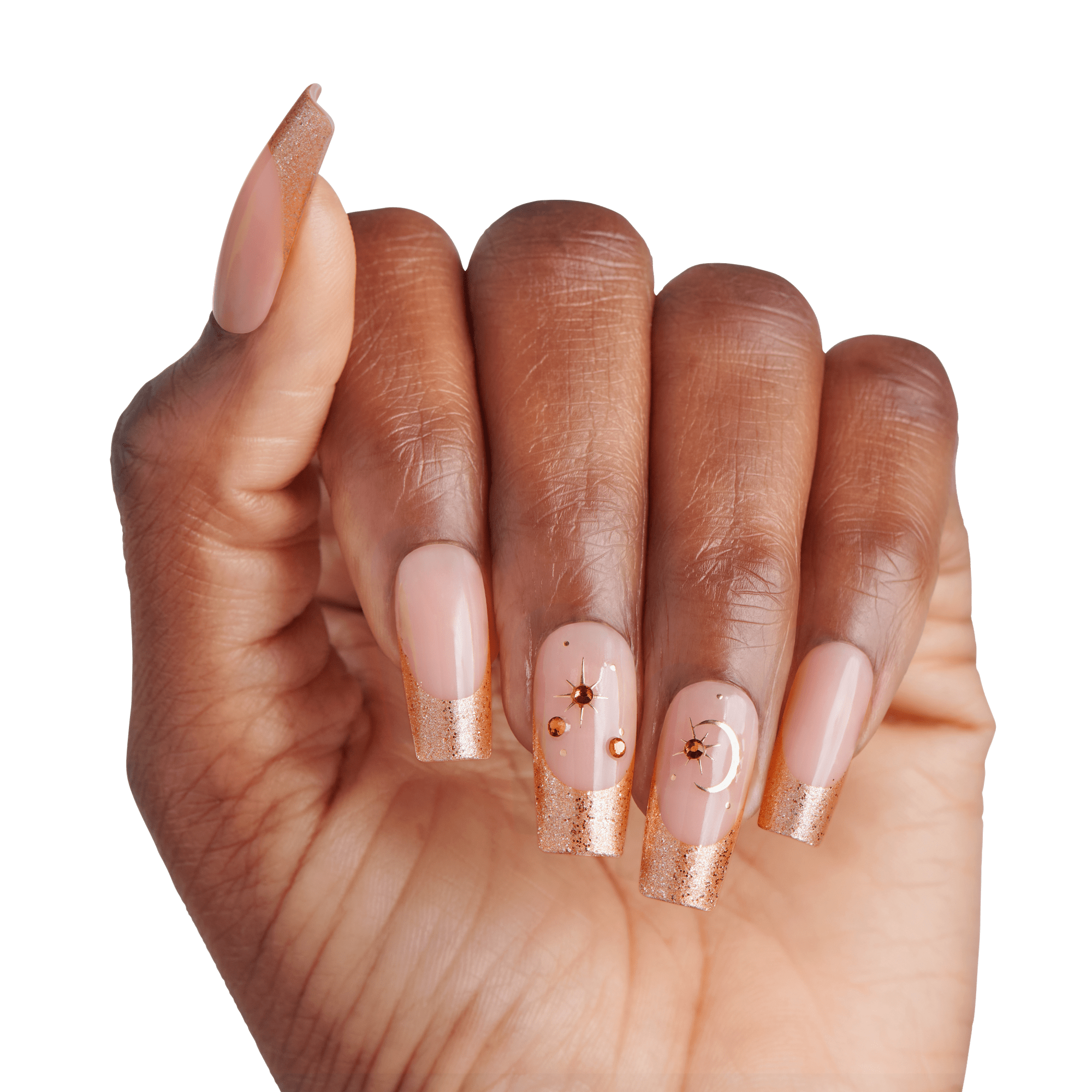 The image features a hand with elegantly manicured nails. The nails are long and shaped with a slight square tip. The base color is a soft nude, complemented by a shimmering gold glitter at the tips. Some nails are adorned with decorative elements, including small gold beads and intricate designs, adding a touch of glamour. The hand is positioned against a plain white background, highlighting the nail art&