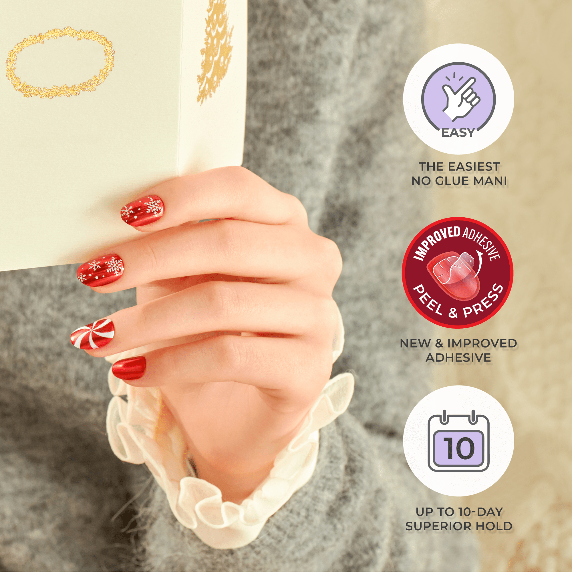 Hand with red holiday-themed press-on nails featuring white snowflakes and a peppermint swirl design, holding a cream-colored gift box. Text highlights easy no-glue application, improved peel-and-press adhesive, and up to 10-day hold.