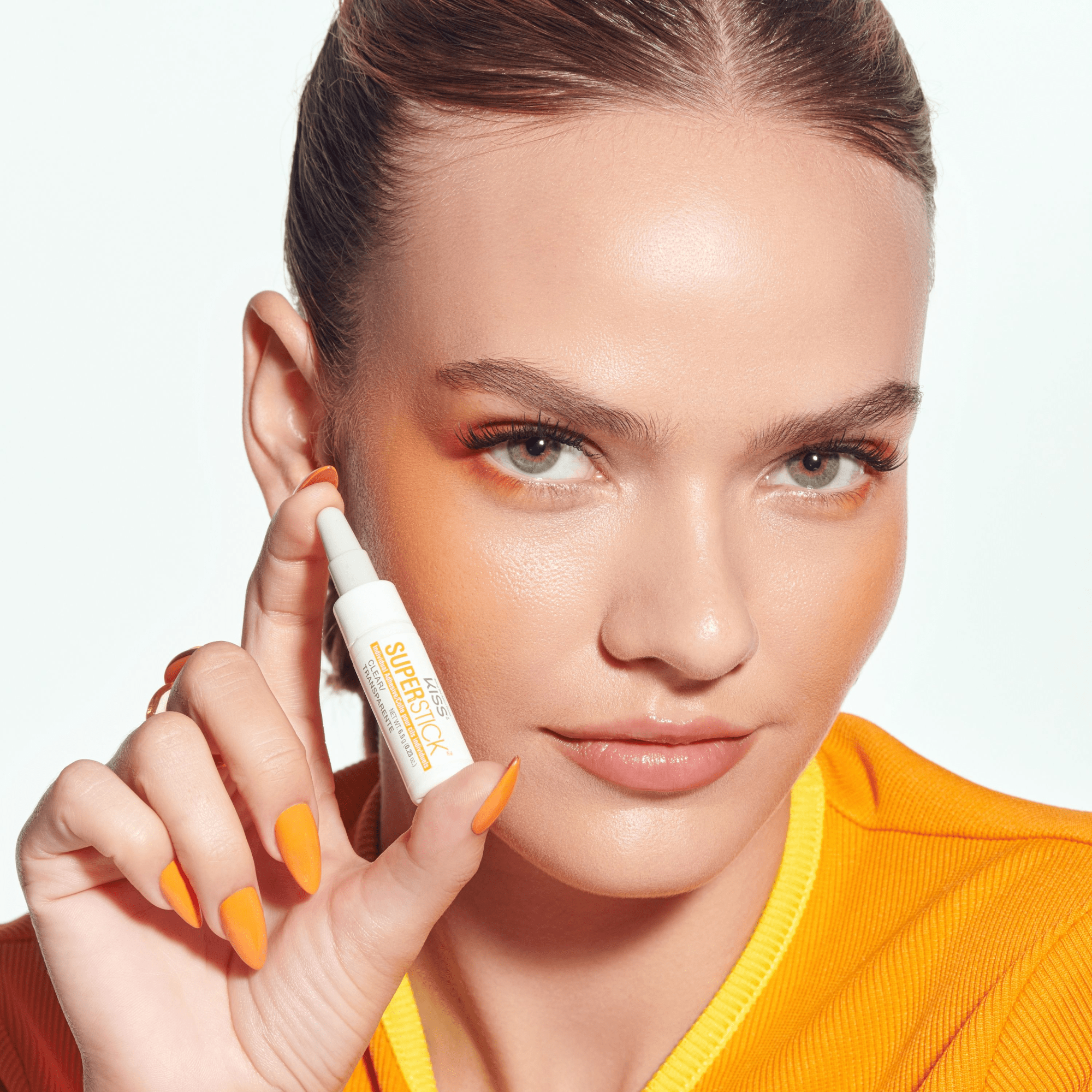Woman holding a skincare product with a white background