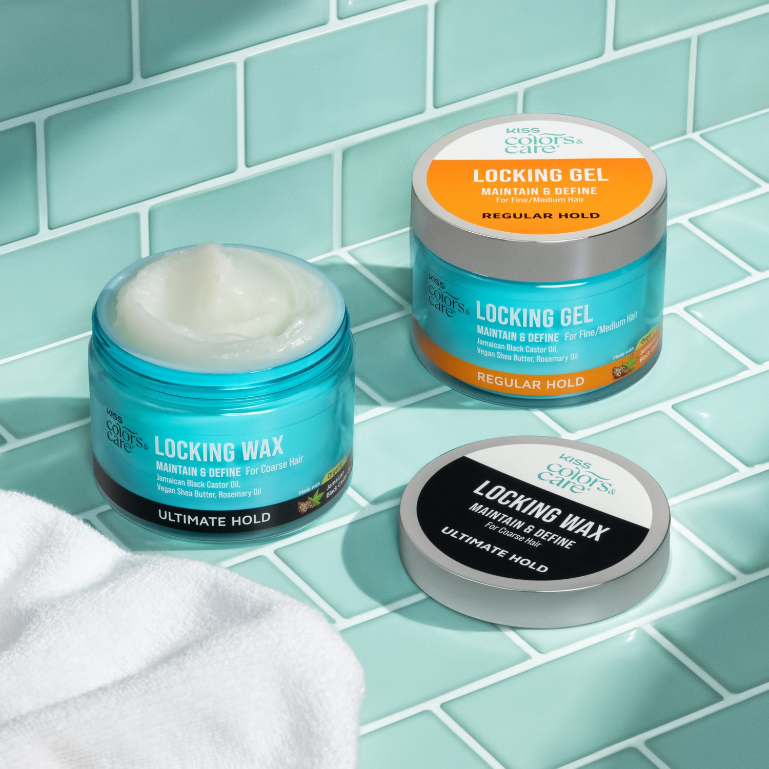 Two blue jars of KISS Colors & Care hair products on aqua tile: one open locking wax with white cream inside, labeled ultimate hold for coarse hair; one closed locking gel jar with orange label, regular hold for fine/me…
