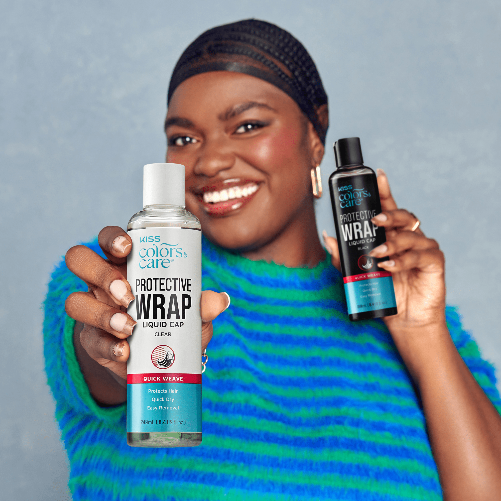 Smiling person in a blue and green striped sweater holds two KISS Colors & Care Protective Wrap Liquid Cap bottles, clear and black, labeled quick weave, protects hair, quick dry, easy removal.