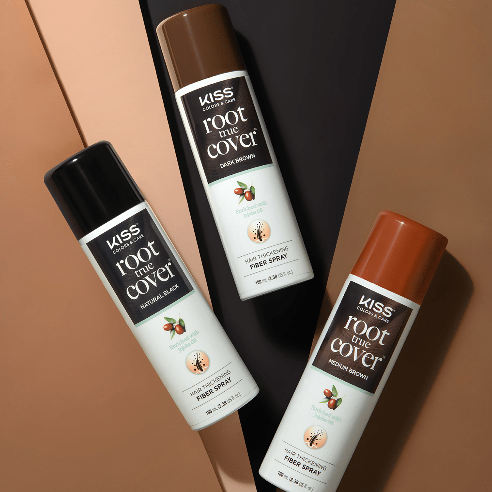 Three KISS Colors & Care Root True Cover hair thickening fiber spray cans in Natural Black, Dark Brown, and Medium Brown, each labeled as enriched with jojoba oil.