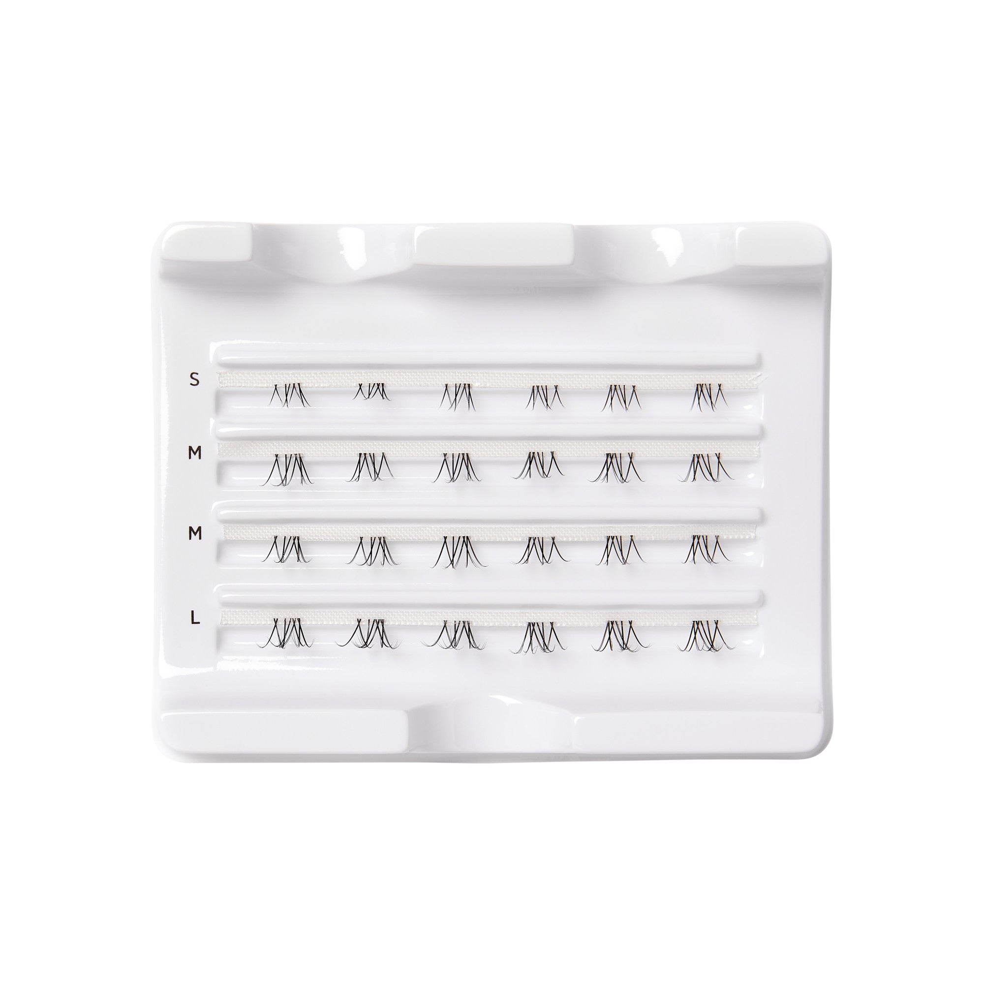 Tray of FALSCARA Wisps Multipack bottom lash clusters in four sizes—small, medium, and large—arranged in rows on white plastic.