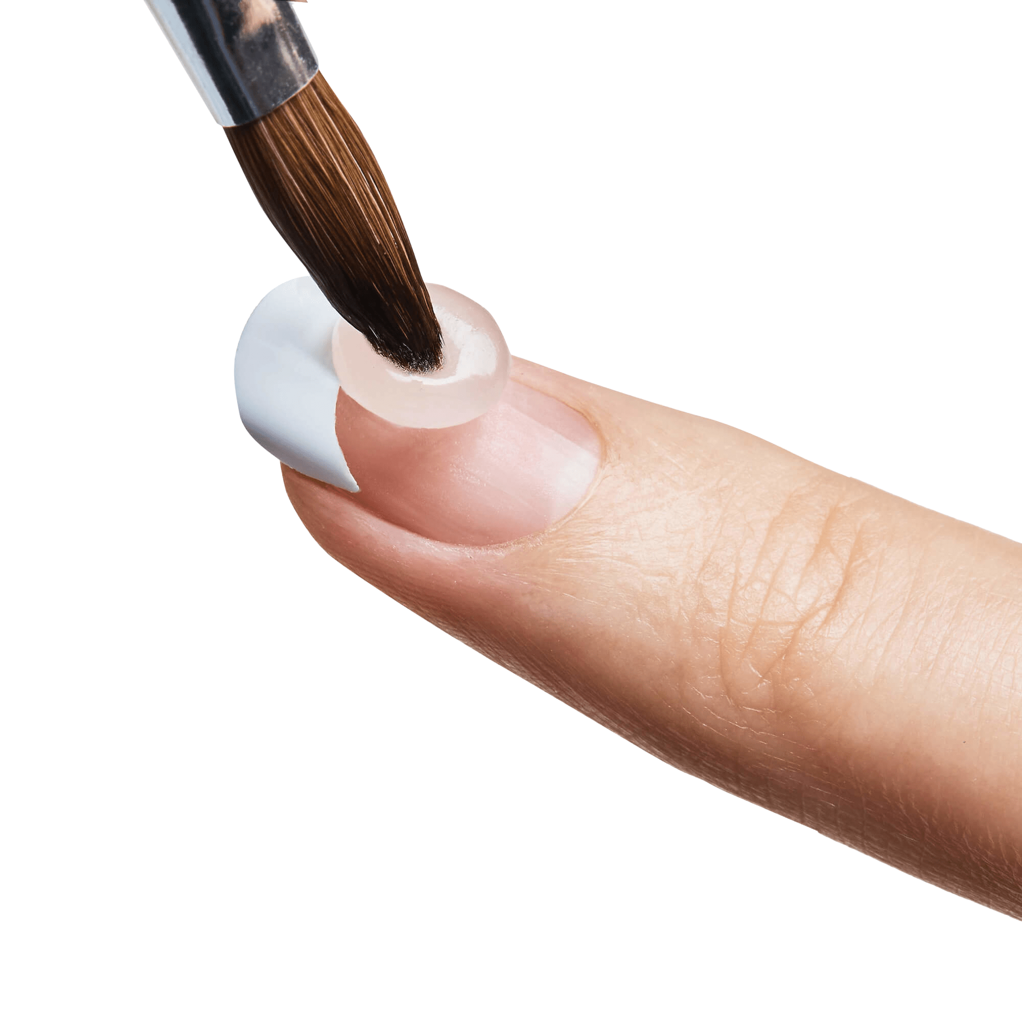 Close-up of a finger with a white acrylic nail tip being filled using a small round brush applying clear acrylic gel.