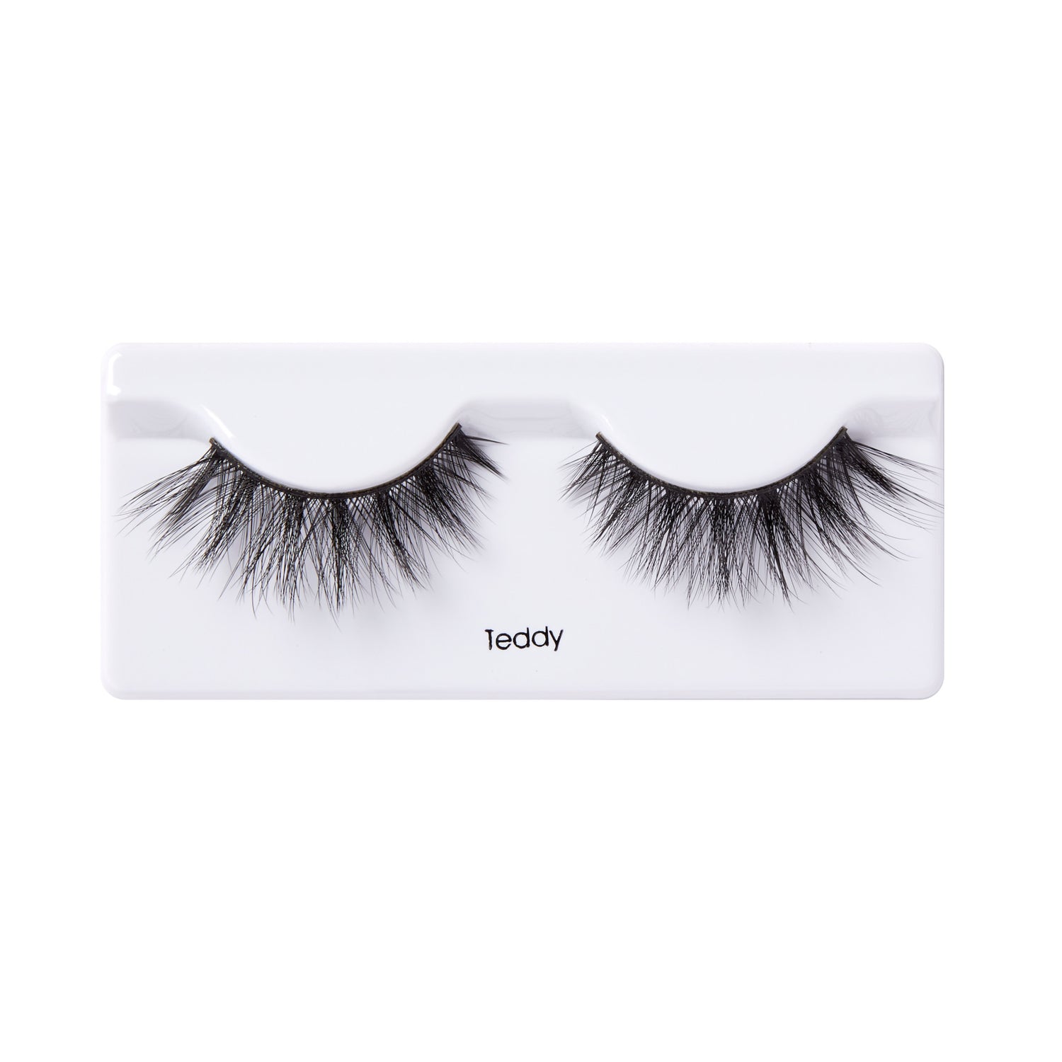 Pair of black, voluminous false eyelashes with a wispy, layered design, displayed on a white plastic tray labeled \