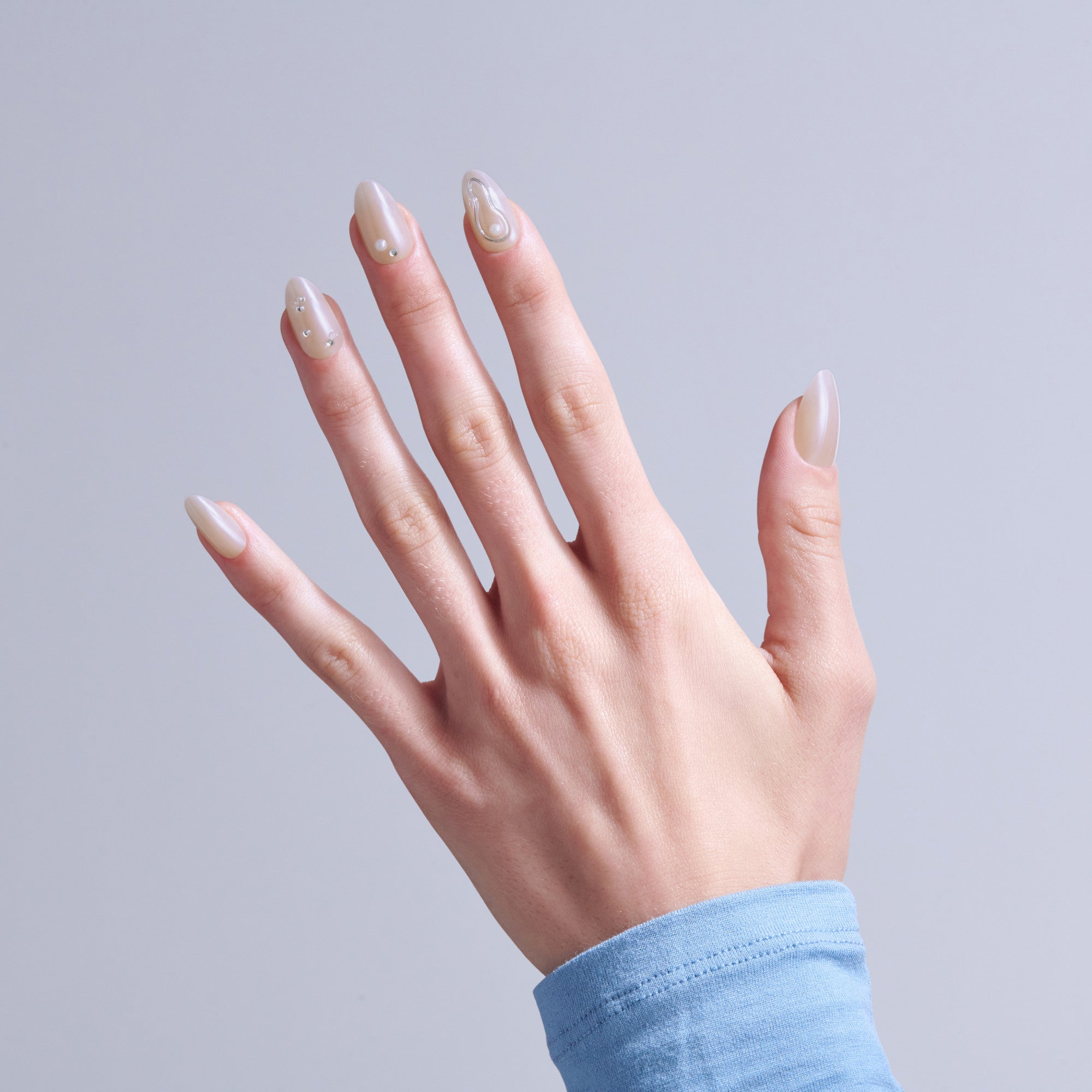 Elegant almond nails with pearlescent nude polish and minimalist line design details.