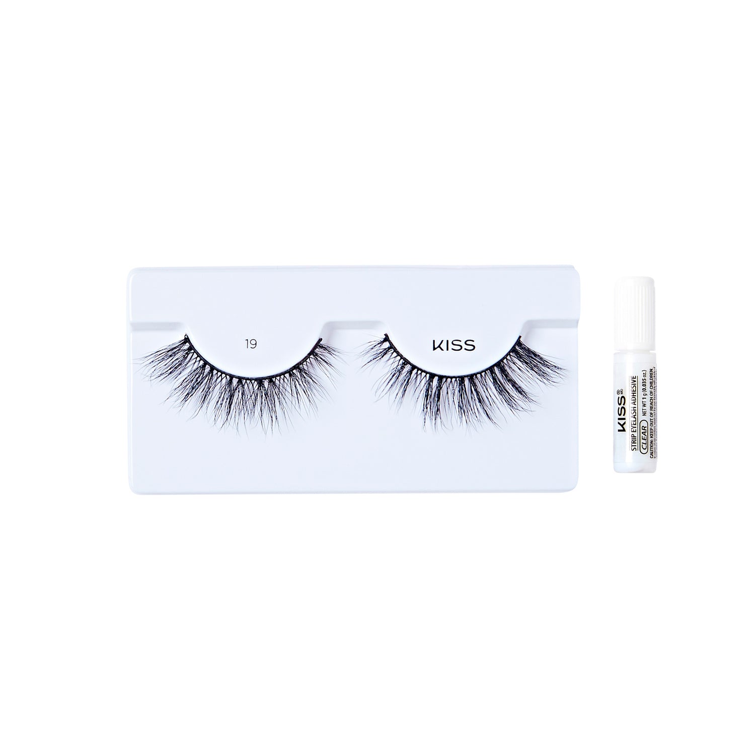 The image shows a set of false eyelashes from the brand "KISS." The eyelashes are displayed on a white tray with the number "19" printed on it. The lashes are long, voluminous, and have a natural, wispy appearance. To the right of the tray, there is a small tube of adhesive glue, also branded with "KISS," which is used to apply the false eyelashes. The overall presentation is clean and minimalistic.