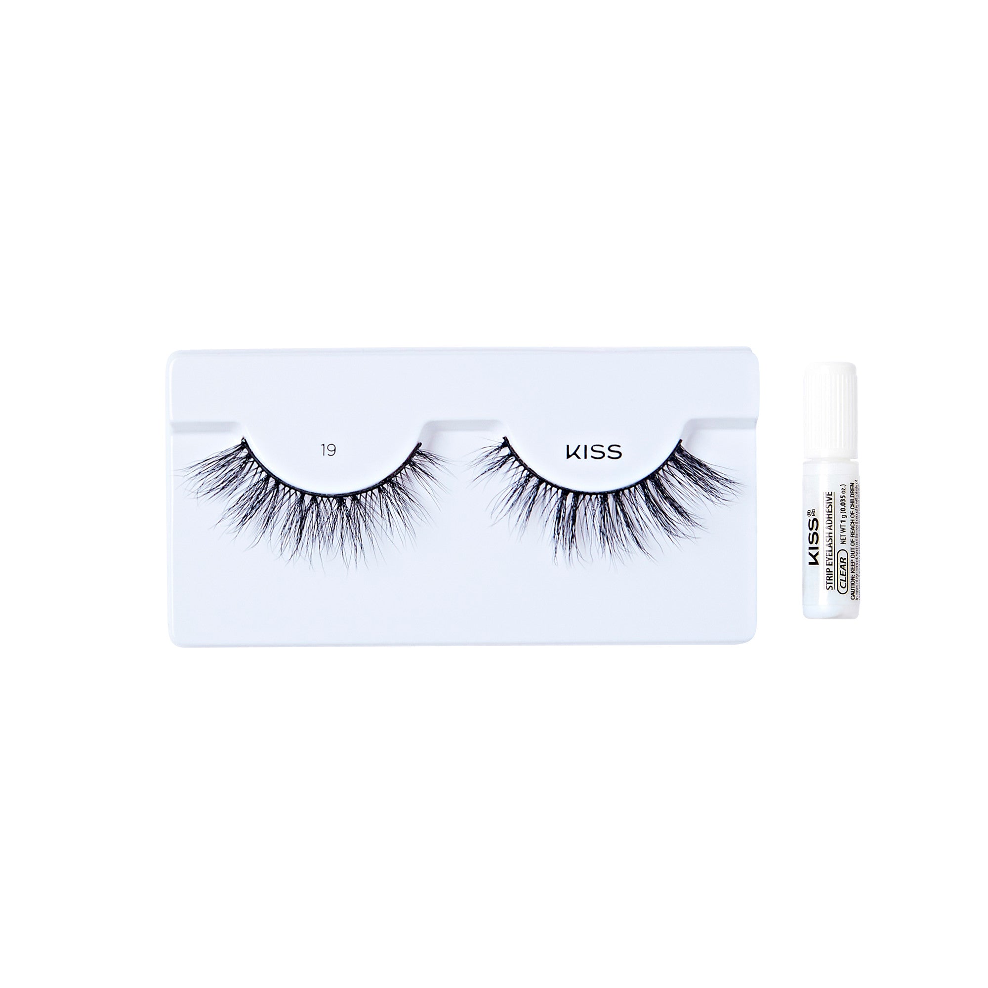 The image shows a set of false eyelashes from the brand "KISS." The eyelashes are displayed on a white tray with the number "19" printed on it. The lashes are long, voluminous, and have a natural, wispy appearance. To the right of the tray, there is a small tube of adhesive glue, also branded with "KISS," which is used to apply the false eyelashes. The overall presentation is clean and minimalistic.