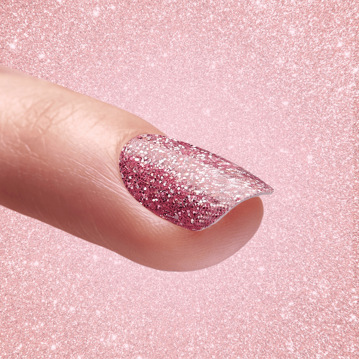 Close-up of a finger with a fingernail coated in pink glitter nail dip powder, set against a sparkling pink glitter background.
