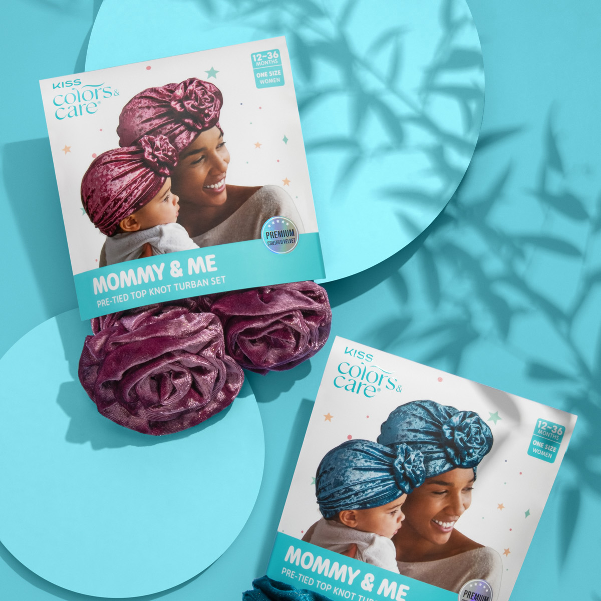 Berry-colored pair of crushed velvet pre-tied top knot turbans in packaging showing a smiling mother and baby wearing matching turbans, labeled \