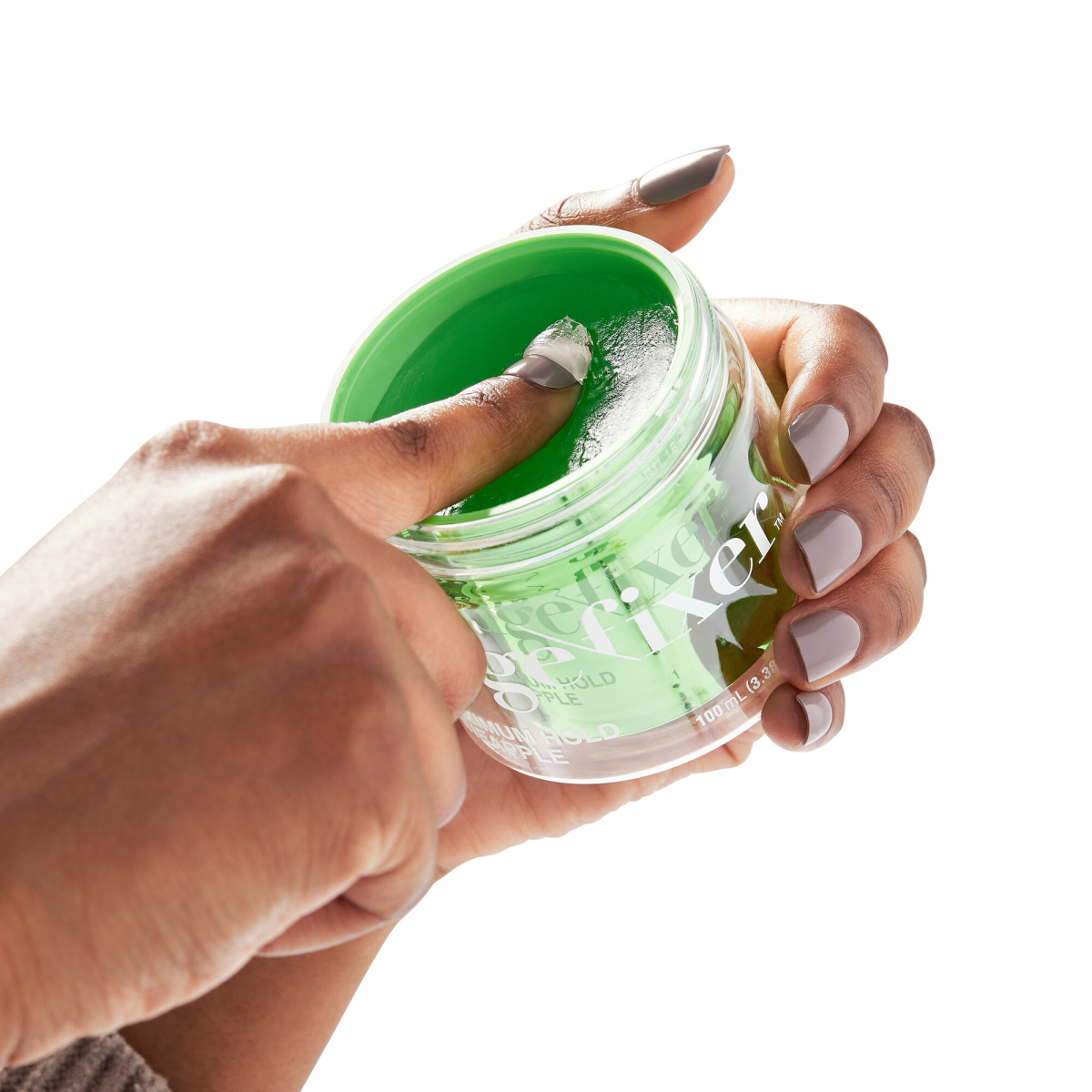 Hand holding an open clear jar of bright green KISS Colors &amp; Care Edge Fixer with finger scooping gel from the 100mL container, labeled maximum hold pineapple.
