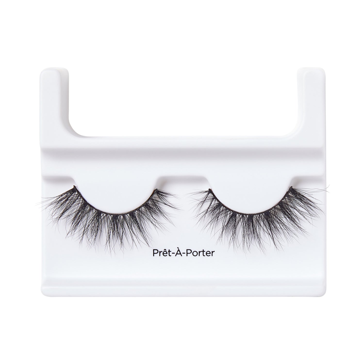 Black voluminous false eyelashes with wispy, crisscrossed strands displayed on a white plastic holder labeled \
