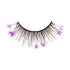 The image shows a single false eyelash strip. The eyelash strip is black and features long, wispy lashes. Attached to the lashes are small, delicate purple flowers, adding a decorative and whimsical touch to the otherwise standard false eyelash design. The flowers are spaced out along the length of the lashes, creating a unique and eye-catching appearance.