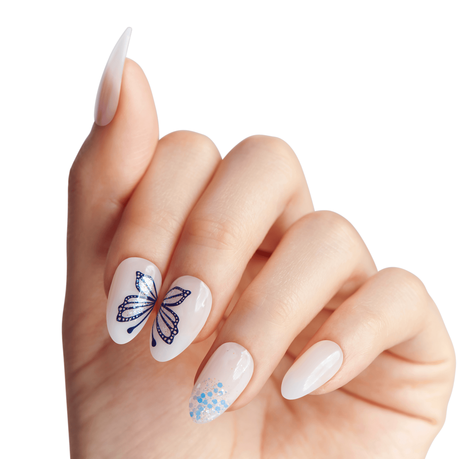 Hand with almond-shaped press-on nails featuring a milky white base, two nails with a dark blue butterfly design split across them, and one nail with blue and silver glitter near the tip.