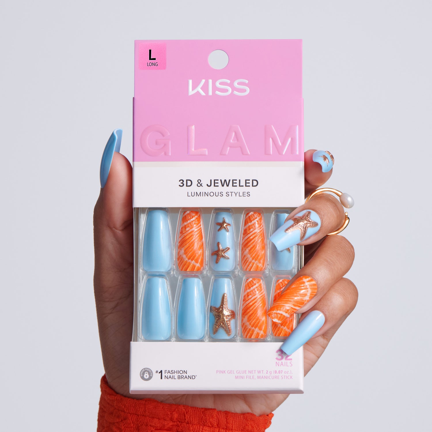 Kiss Glam 3D &amp; Jeweled nail art set held by a hand with blue and orange nail designs.