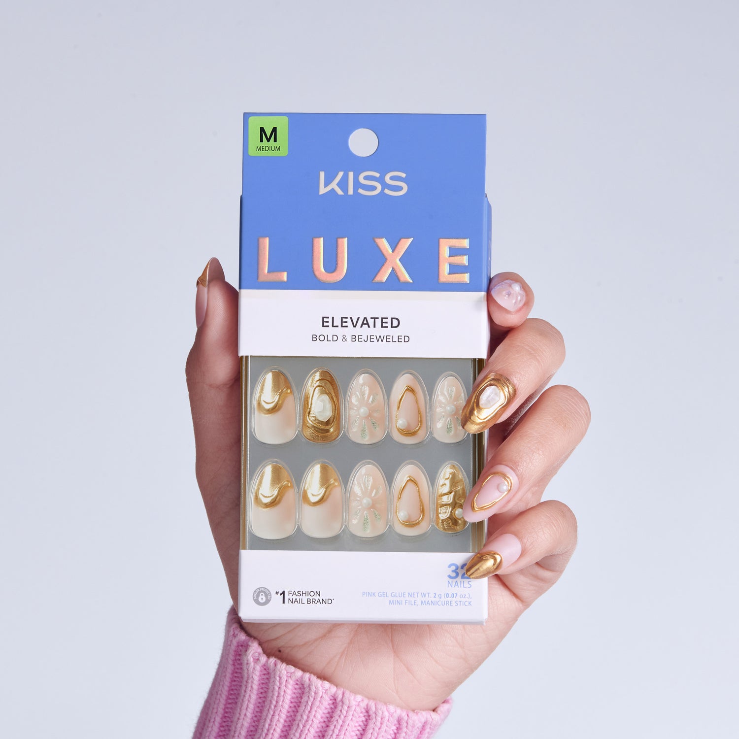 KISS Luxe Elevated medium nail set with gold and cream designs in hand