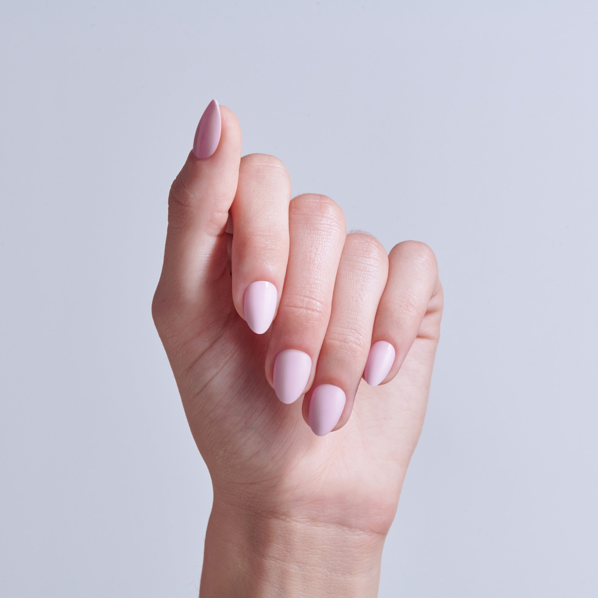 Hand displaying almond-shaped nails with pink and mauve nail polish shades.