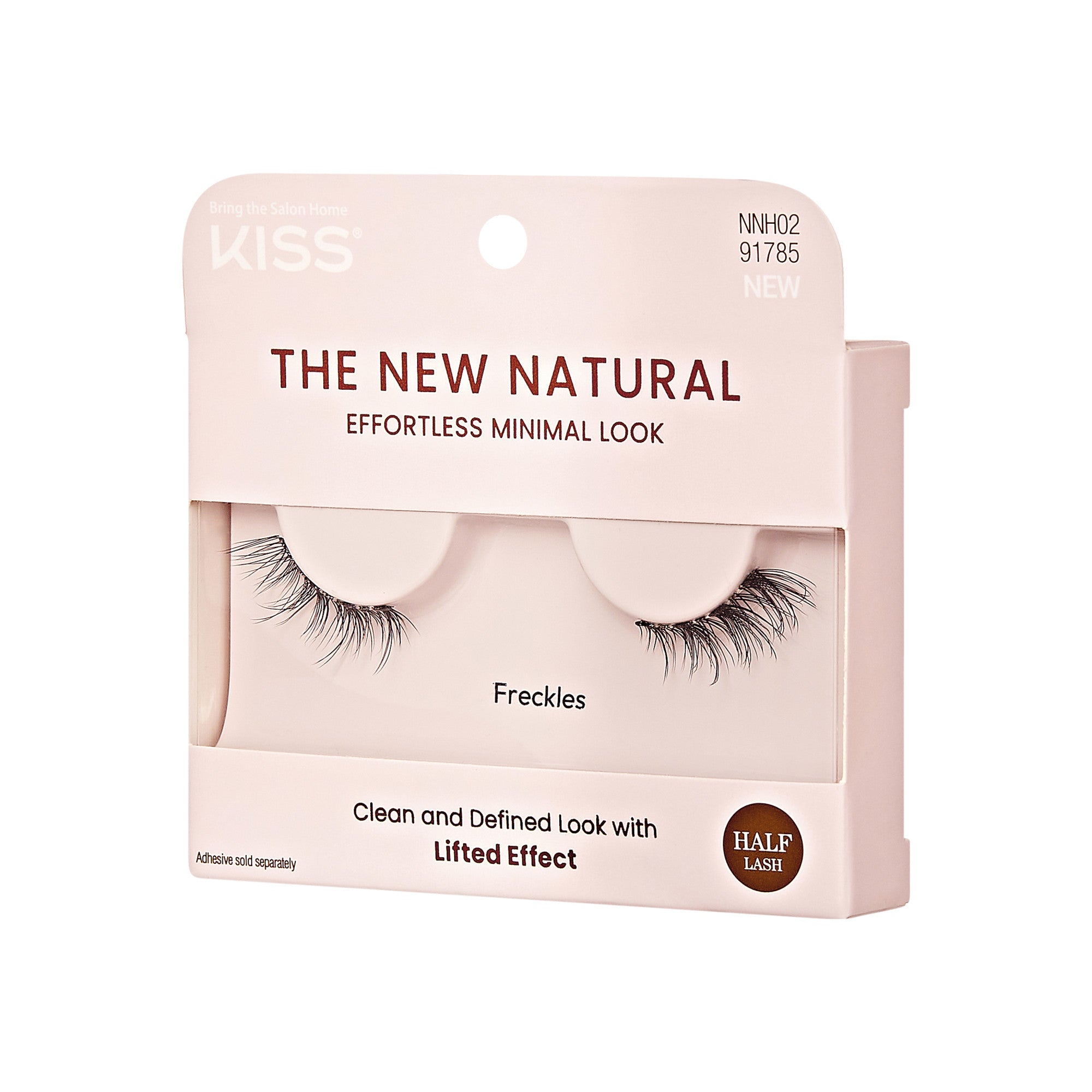 The image shows a package of false eyelashes from the brand "Kiss." The product is labeled "The New Natural" and is designed to provide an "Effortless Minimal Look." The specific style of the eyelashes is called "Freckles." The packaging also highlights that the lashes offer a "Clean and Defined Look with Lifted Effect." Additionally, it mentions that the product is a "Half Lash" and that adhesive is sold separately. The packaging is primarily a light pink color with black text.