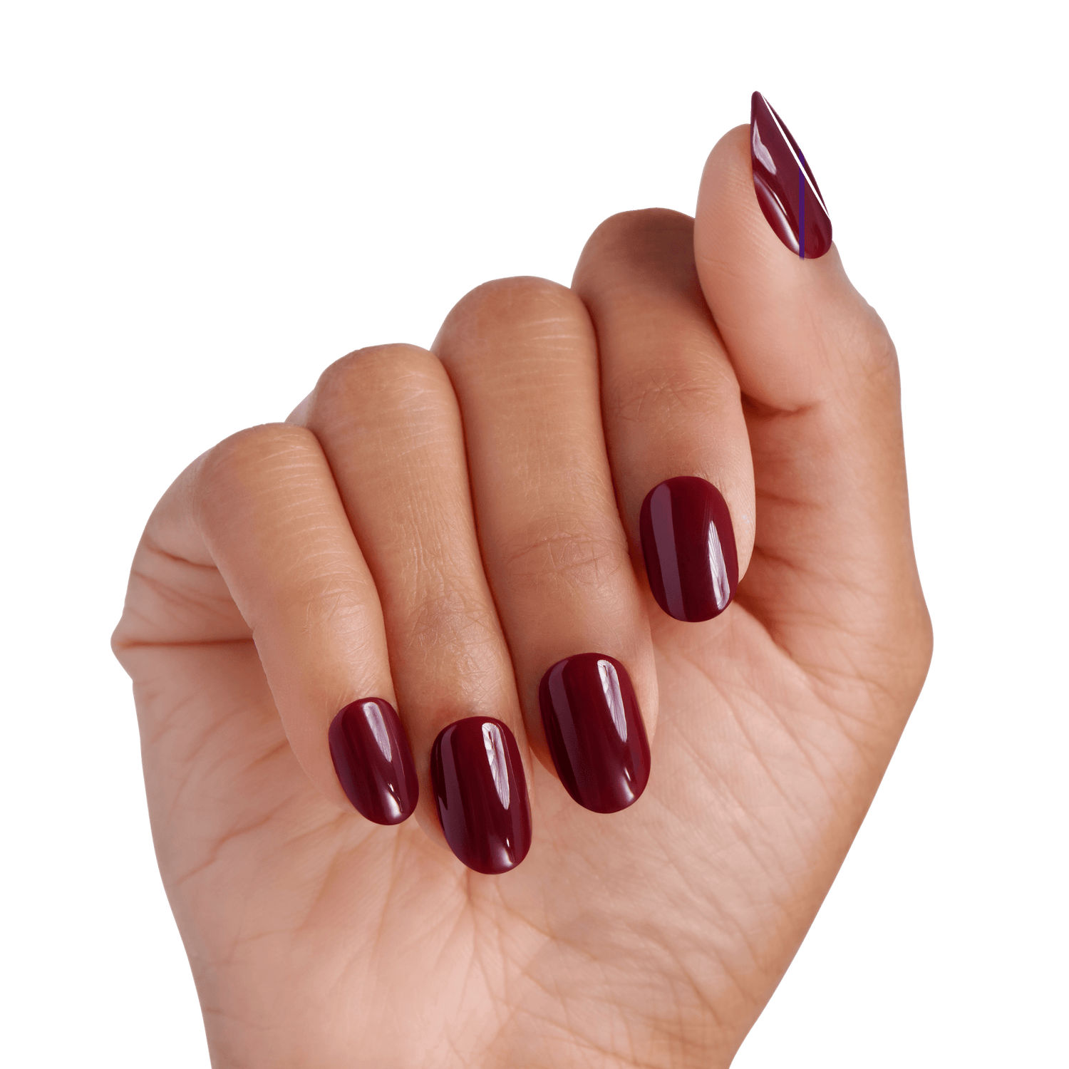 Hand with short, rounded press-on nails painted in a glossy deep burgundy shade called \