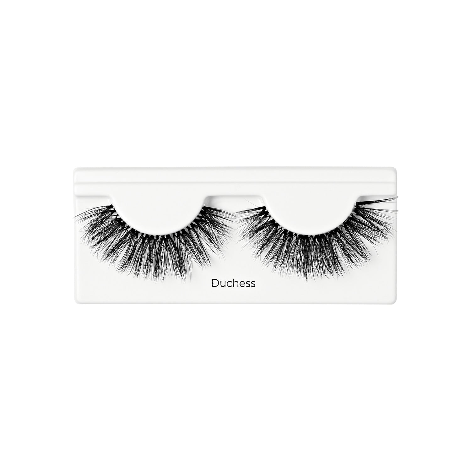 Pair of black, voluminous false lashes with layered, wispy fibers displayed on white tray labeled \