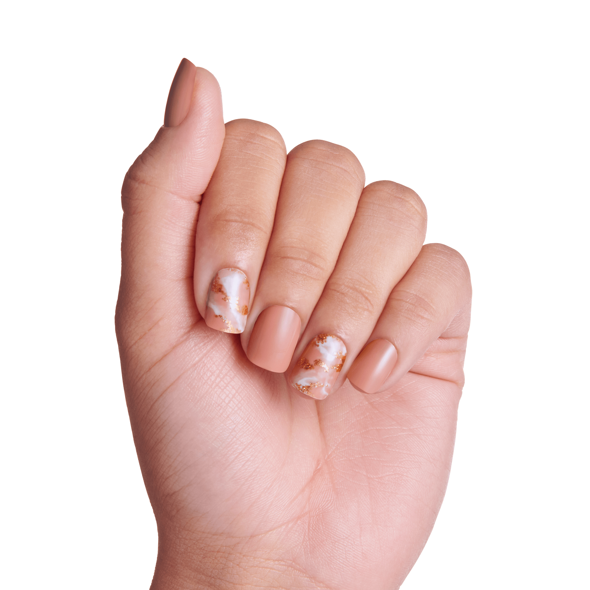 Hand with medium skin tone showing press-on nails featuring a matte nude color and two accent nails with white and copper marbled design.