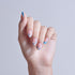 Manicured nails with pink base, blue accents, and floral designs on light background.