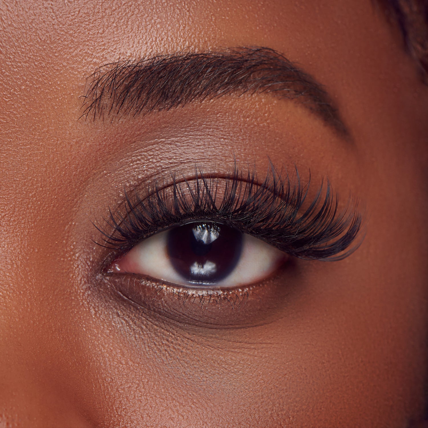 The image features a close-up of a human eye, showcasing long, voluminous eyelashes that enhance the eye&