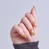 Almond nails with gold trim and pearl accents on natural pink base.