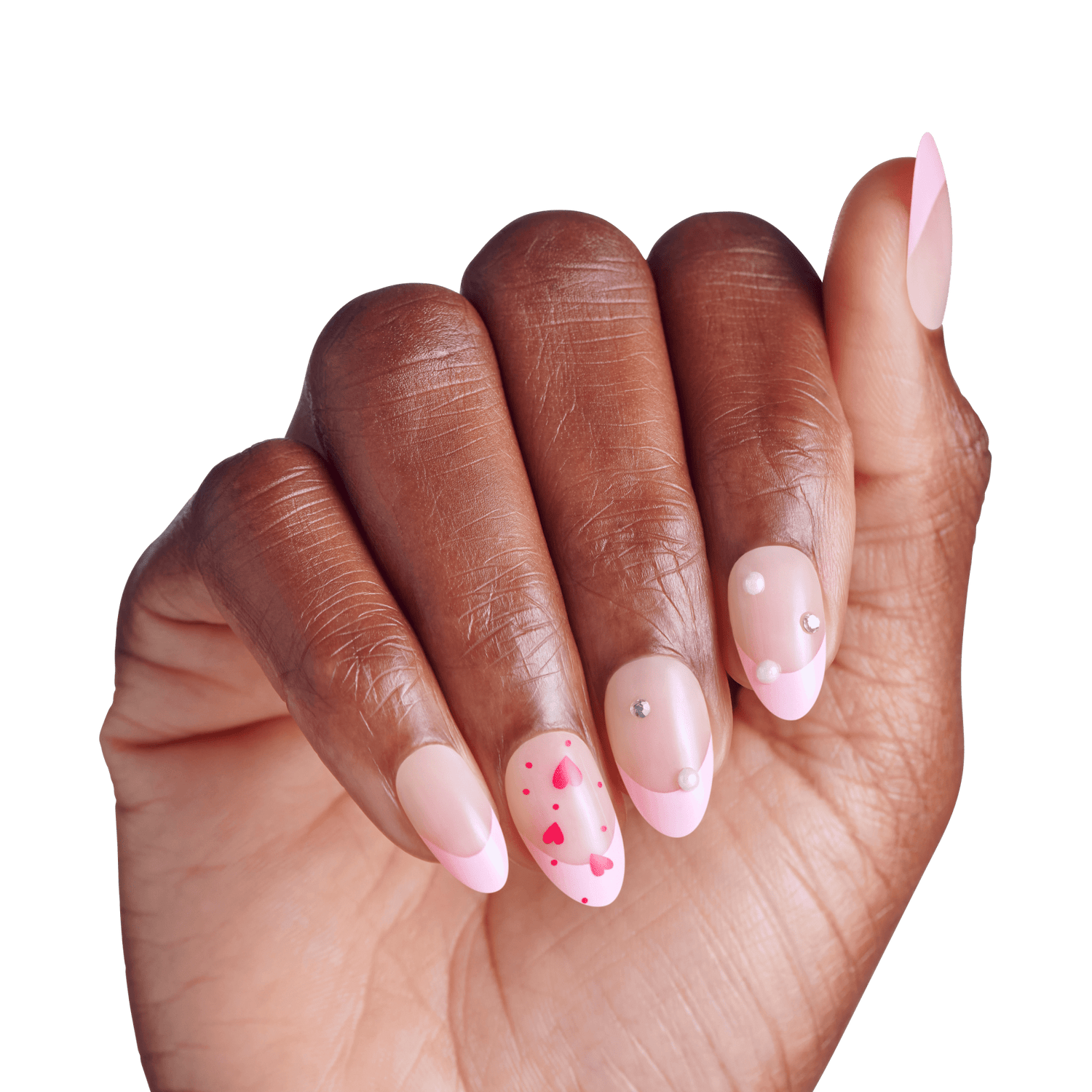 Almond nails with pink polish, rhinestones, and heart designs on dark skin hand.
