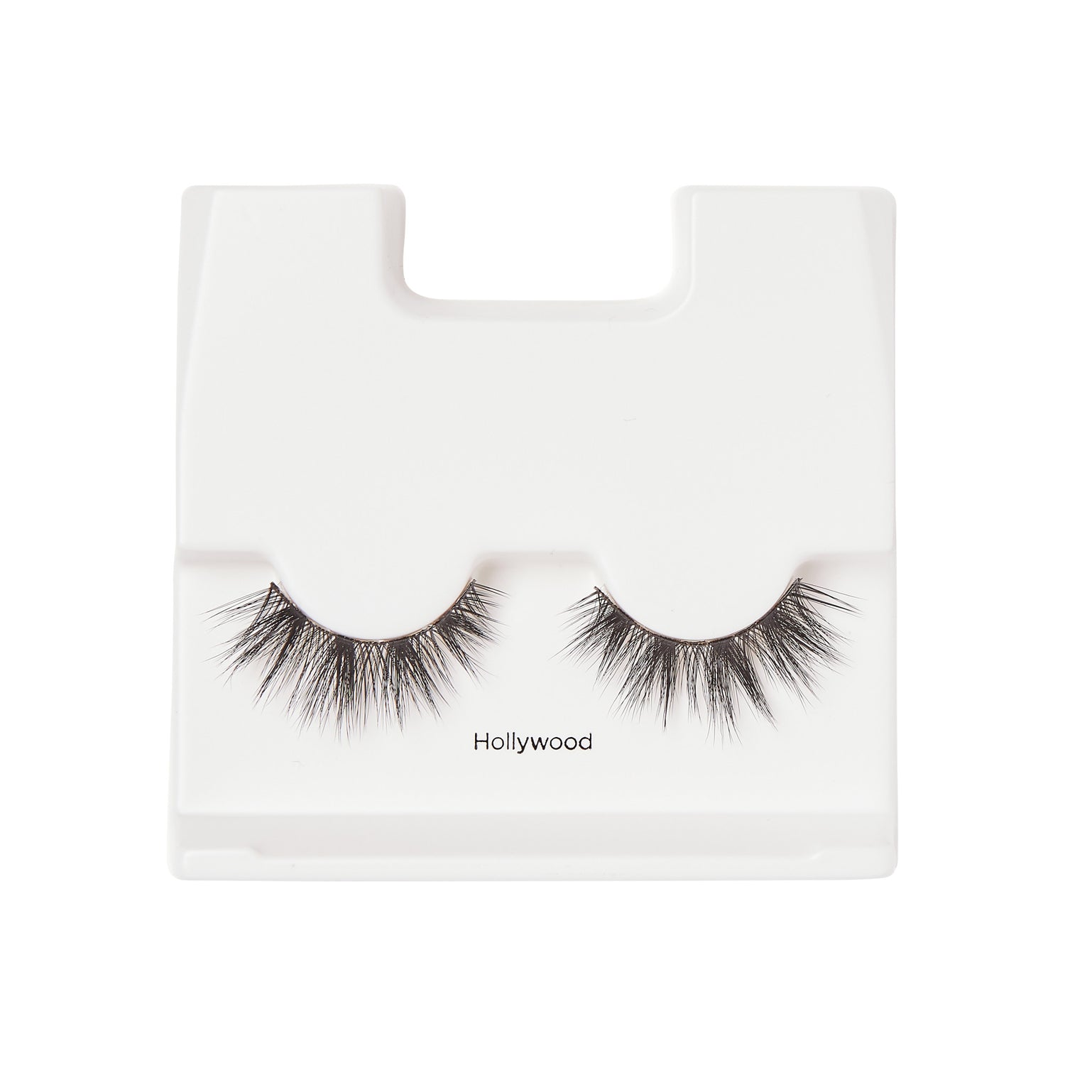 Pair of black false eyelashes with a fluttery, voluminous style displayed on a white plastic tray labeled \