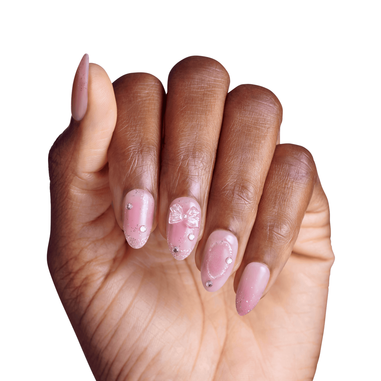Manicured hand displaying pink gel nails with rhinestone embellishments and bow design.