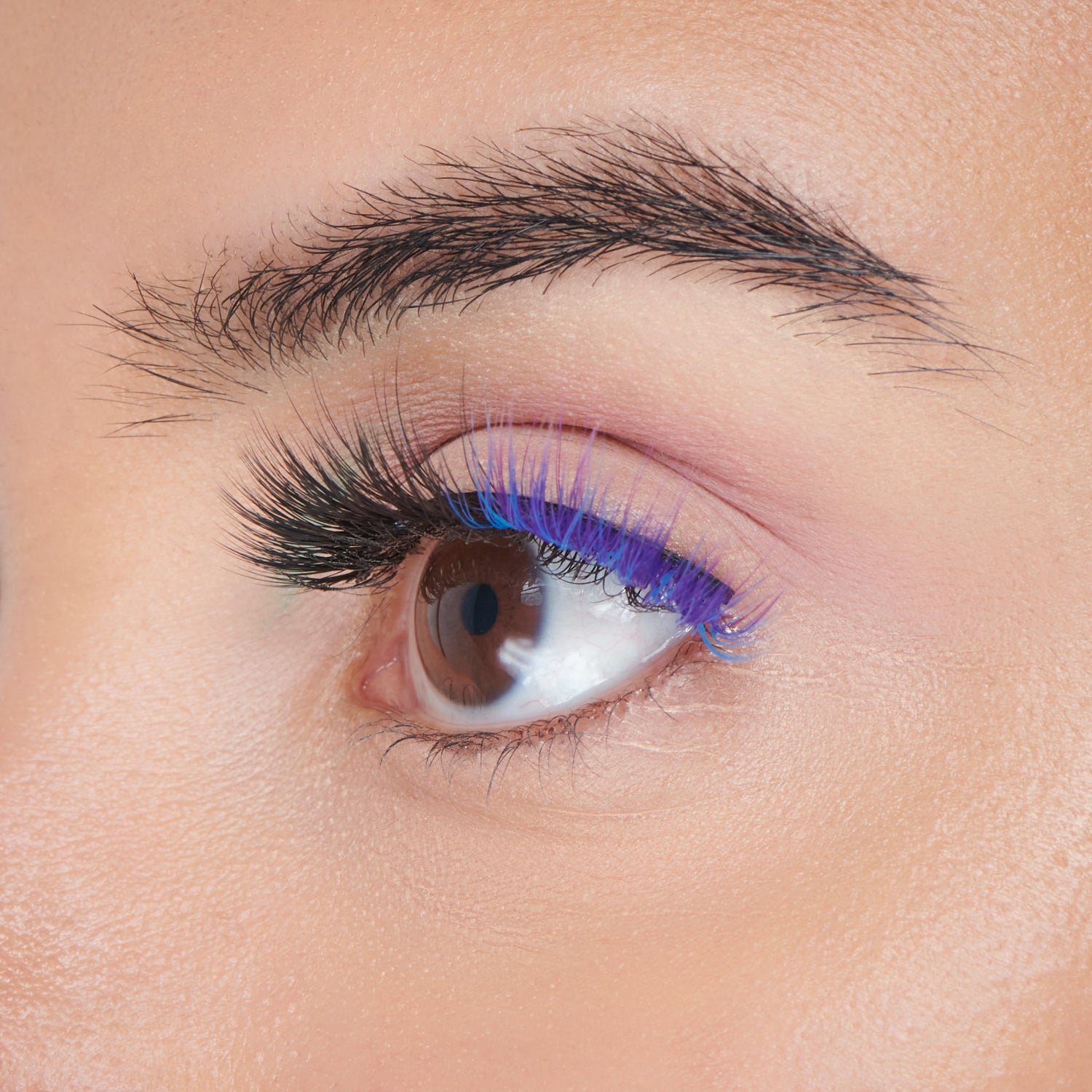 Close-up of eye with blue and purple eyeshadow, black eyeliner, and false lashes.