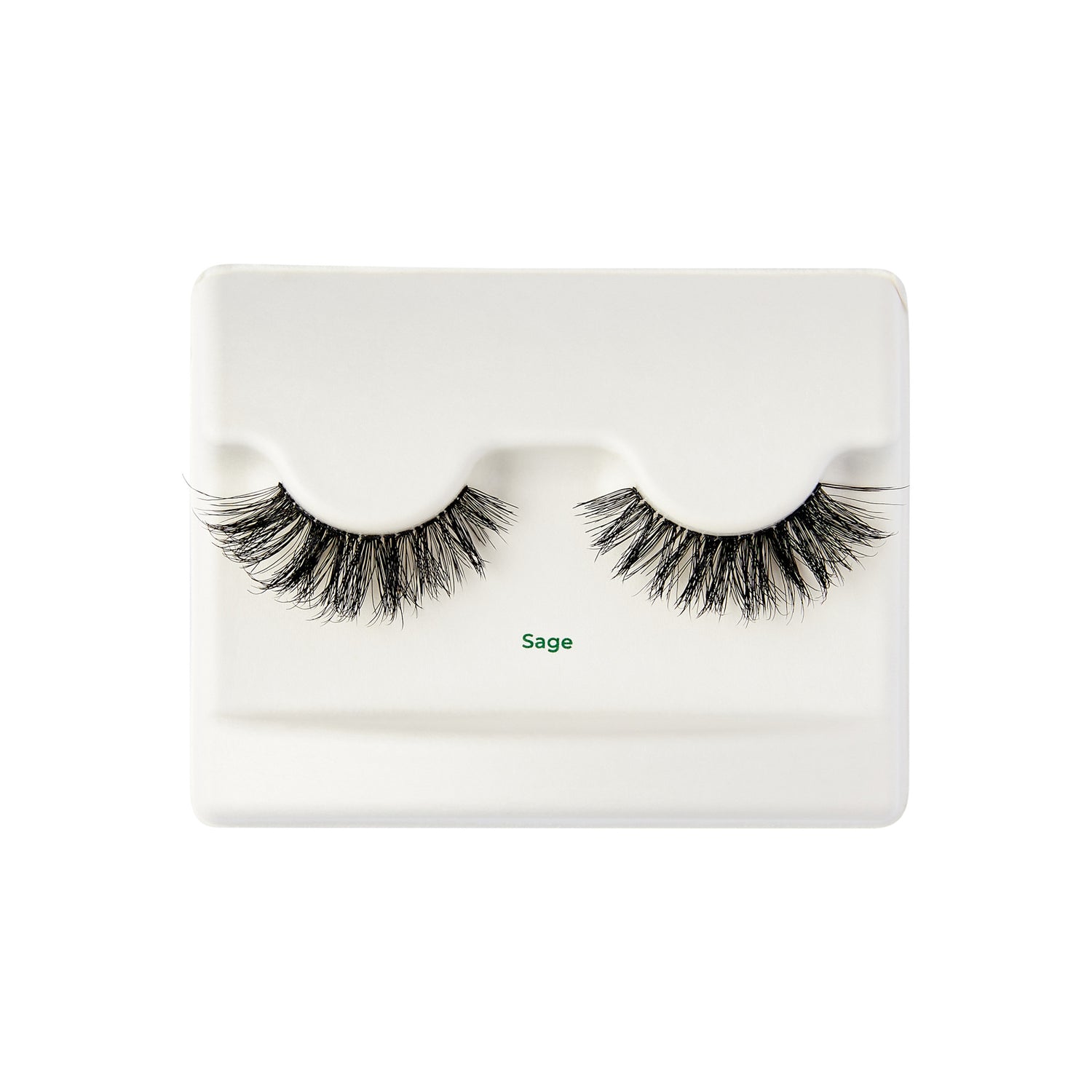The image shows a pair of false eyelashes displayed on a white plastic tray. The eyelashes are thick and voluminous, with a natural-looking curl. The tray has a slight indentation to hold the lashes in place. Below the lashes, the word "Sage" is printed in green text. The overall presentation is clean and minimalistic.