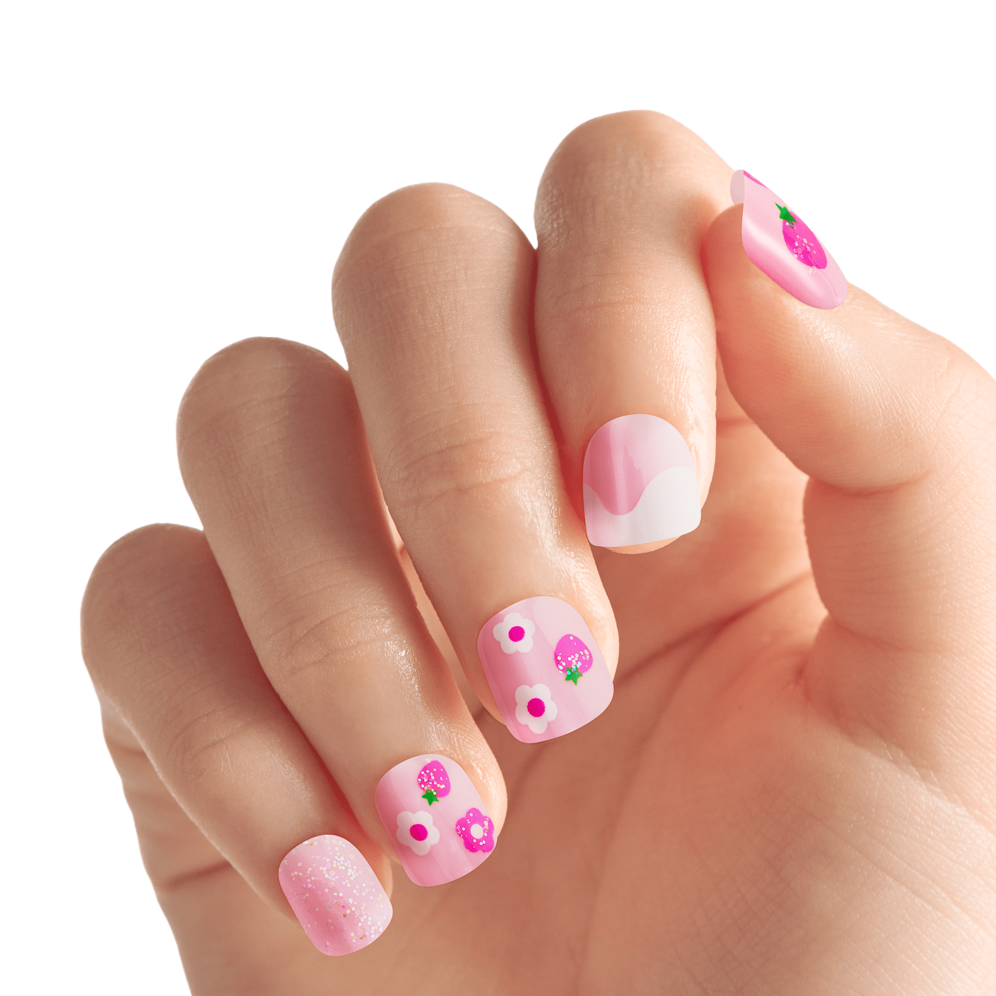 Child’s hand showing short, square, pink press-on nails with playful designs including strawberries, white and purple flowers, and glitter accents.