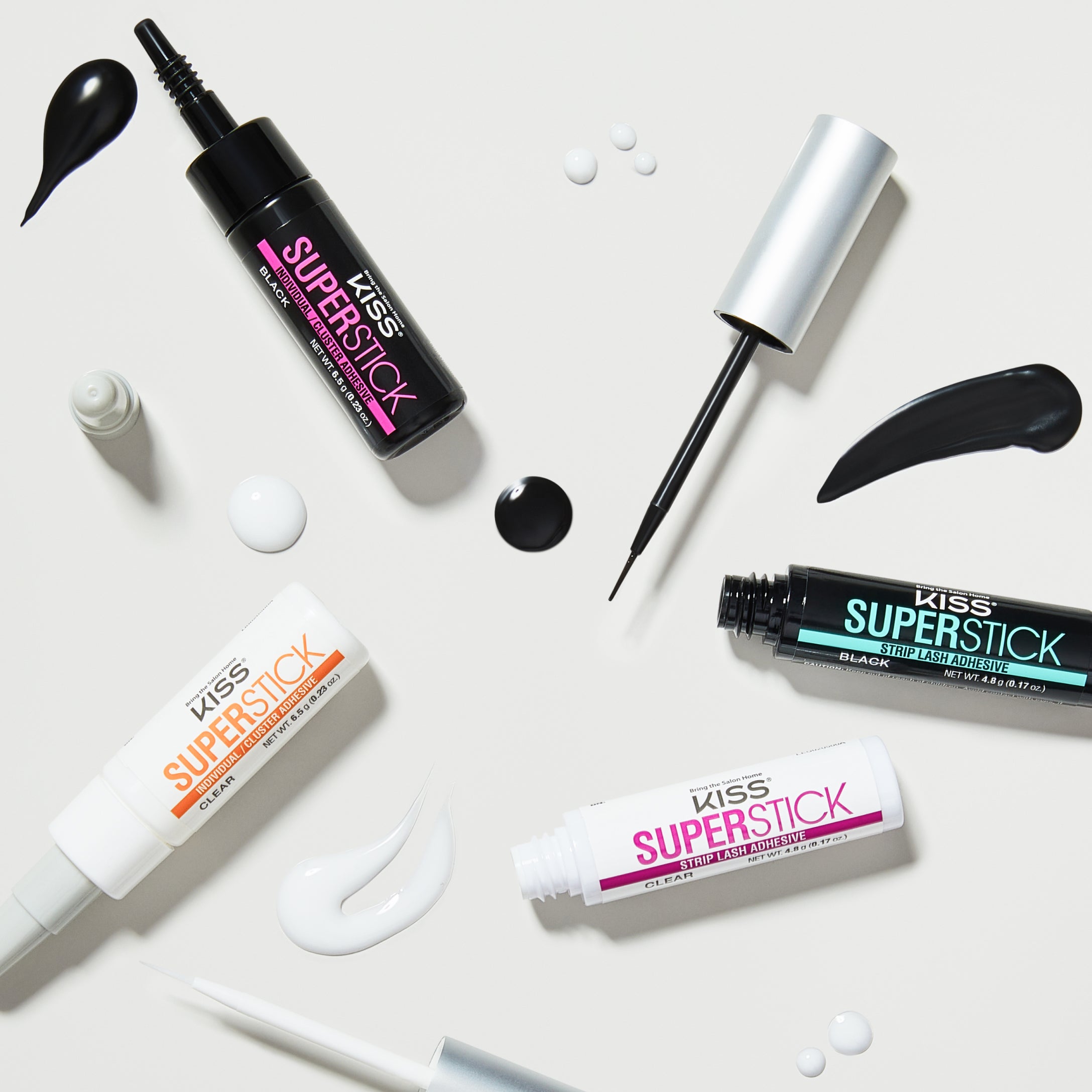 Kiss Superstick lash adhesive products displayed with applicators and swatches on white background.