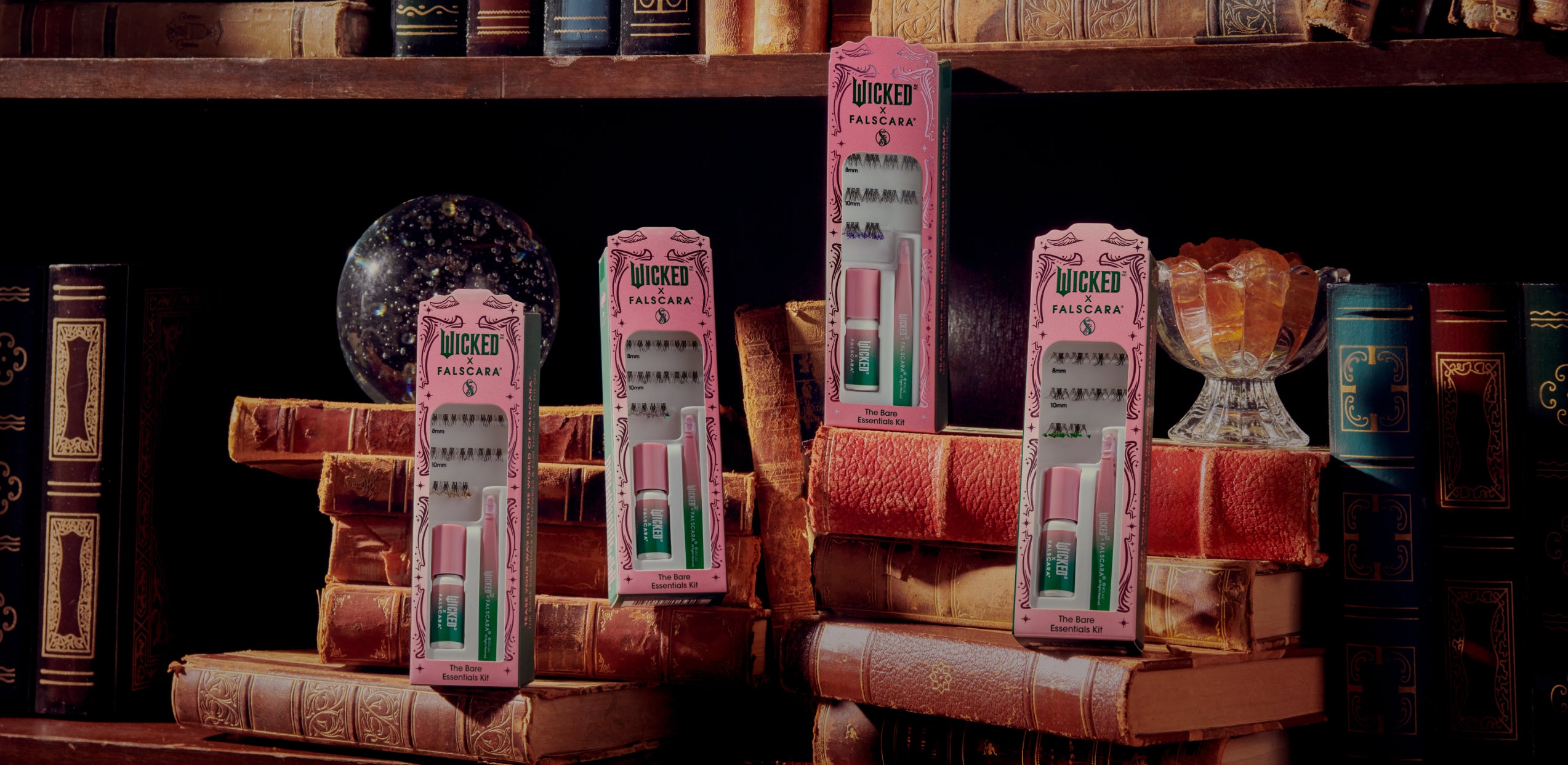 Wicked x Falscara lash kits displayed on vintage books and decorative objects.
